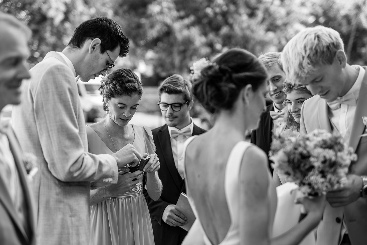 A sequence of black and white photos showing people sharing emotional moments at a wedding celebration.