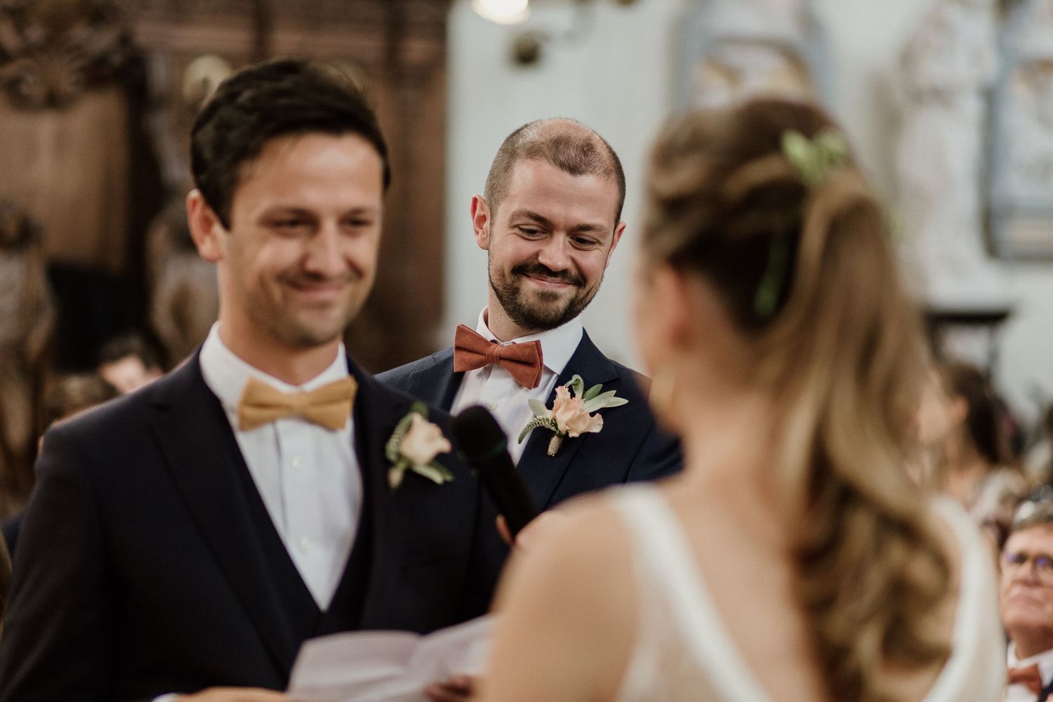 A joyful wedding ceremony scene with guests seated in a church as the couple exchanges vows at the altar.