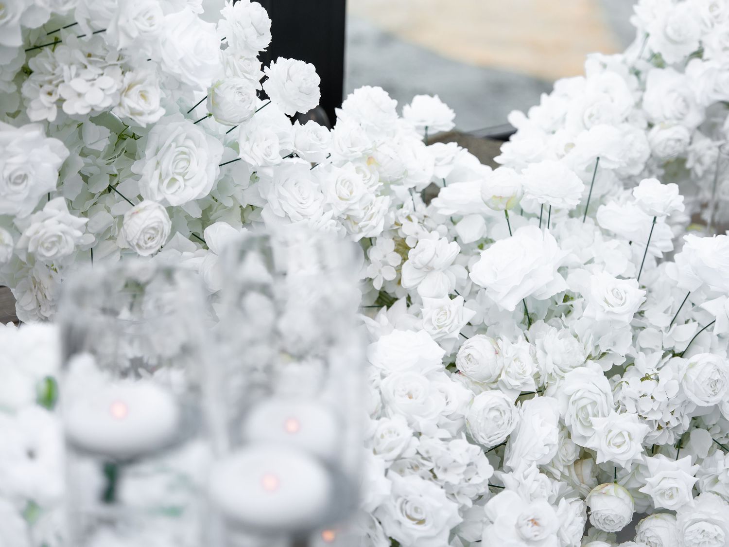 Lush white floral wedding arrangement featuring roses and baby's breath creating an elegant all-white display.