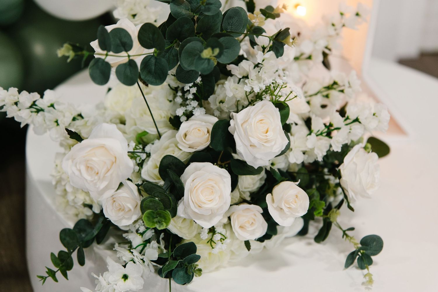 White roses and eucalyptus bouquet with baby's breath for an elegant floral arrangement.