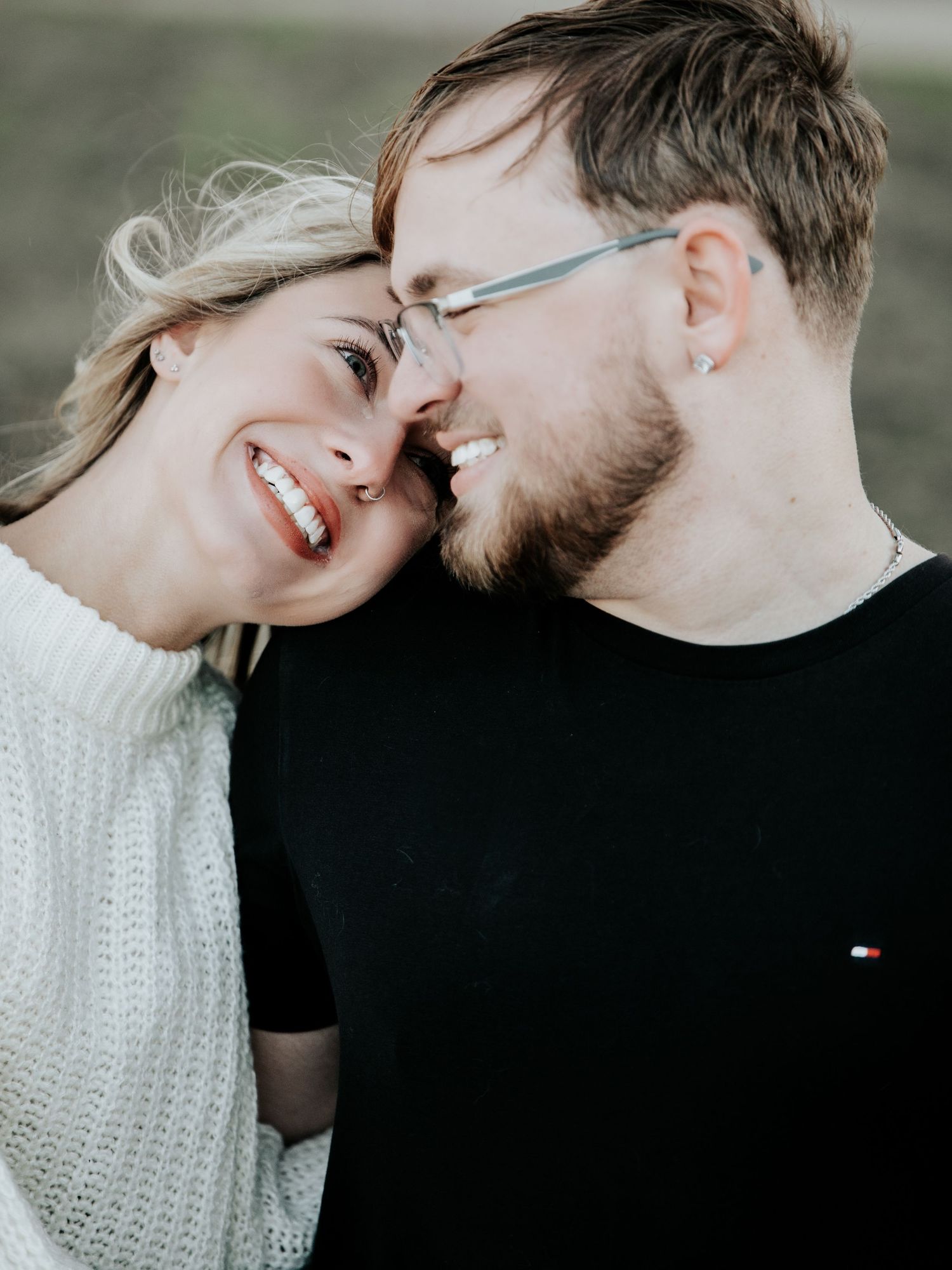 Happy couple smiling and touching foreheads in a tender romantic outdoor close-up portrait.