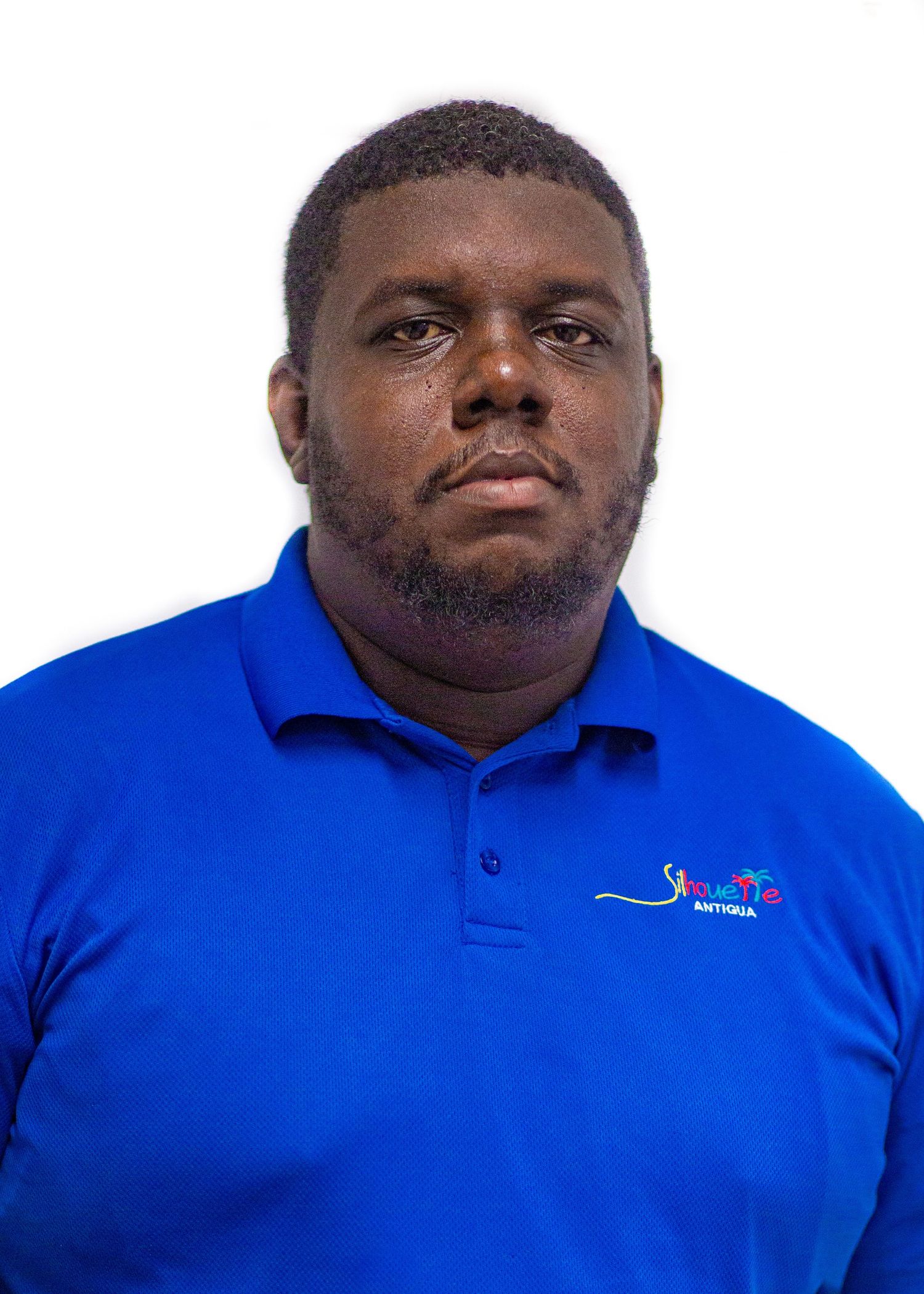 Travis in a blue Antigua polo shirt posing for a professional headshot photo against a white background.