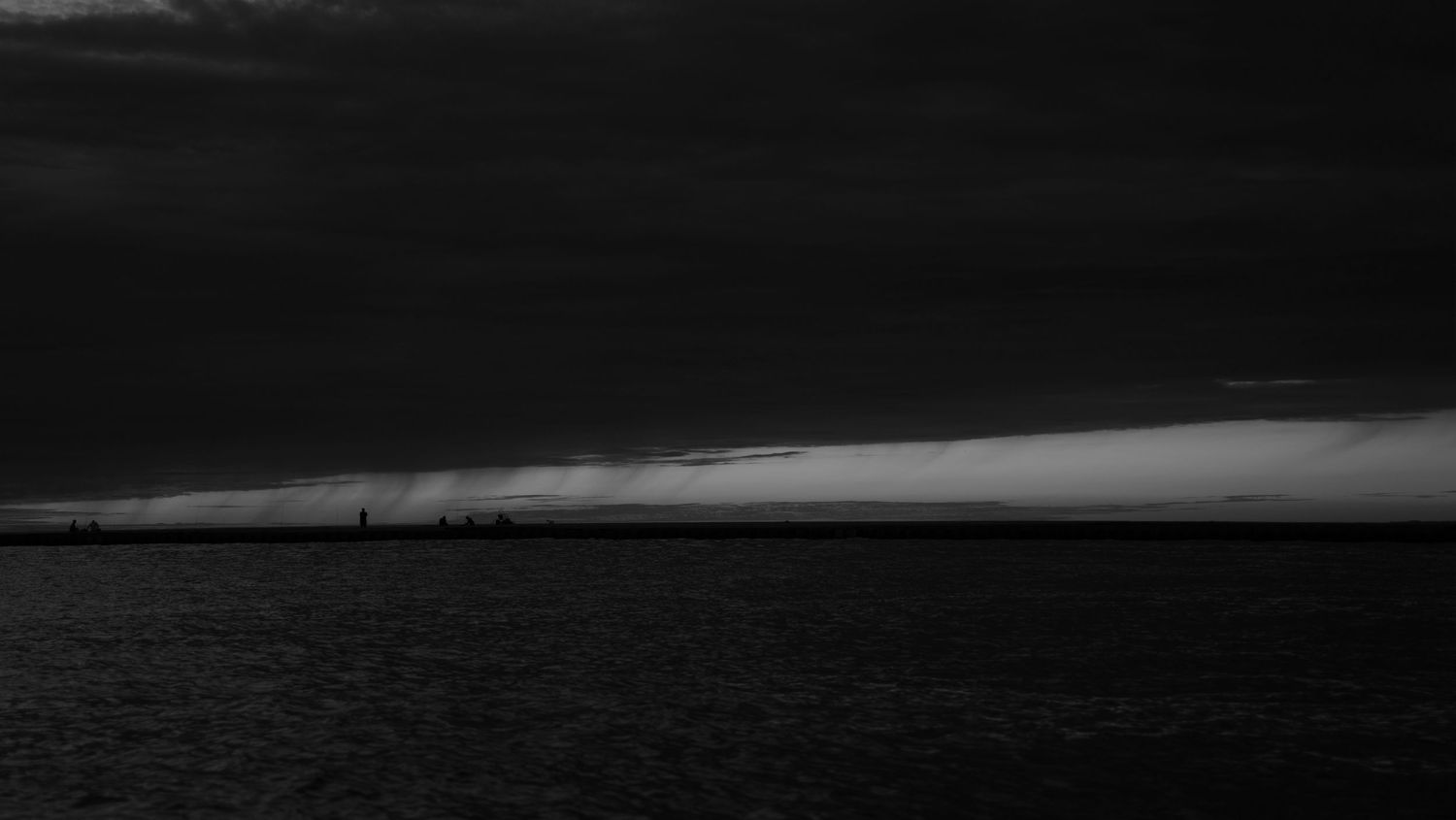 Dark dramatic black and white seascape with stormy clouds over ocean.