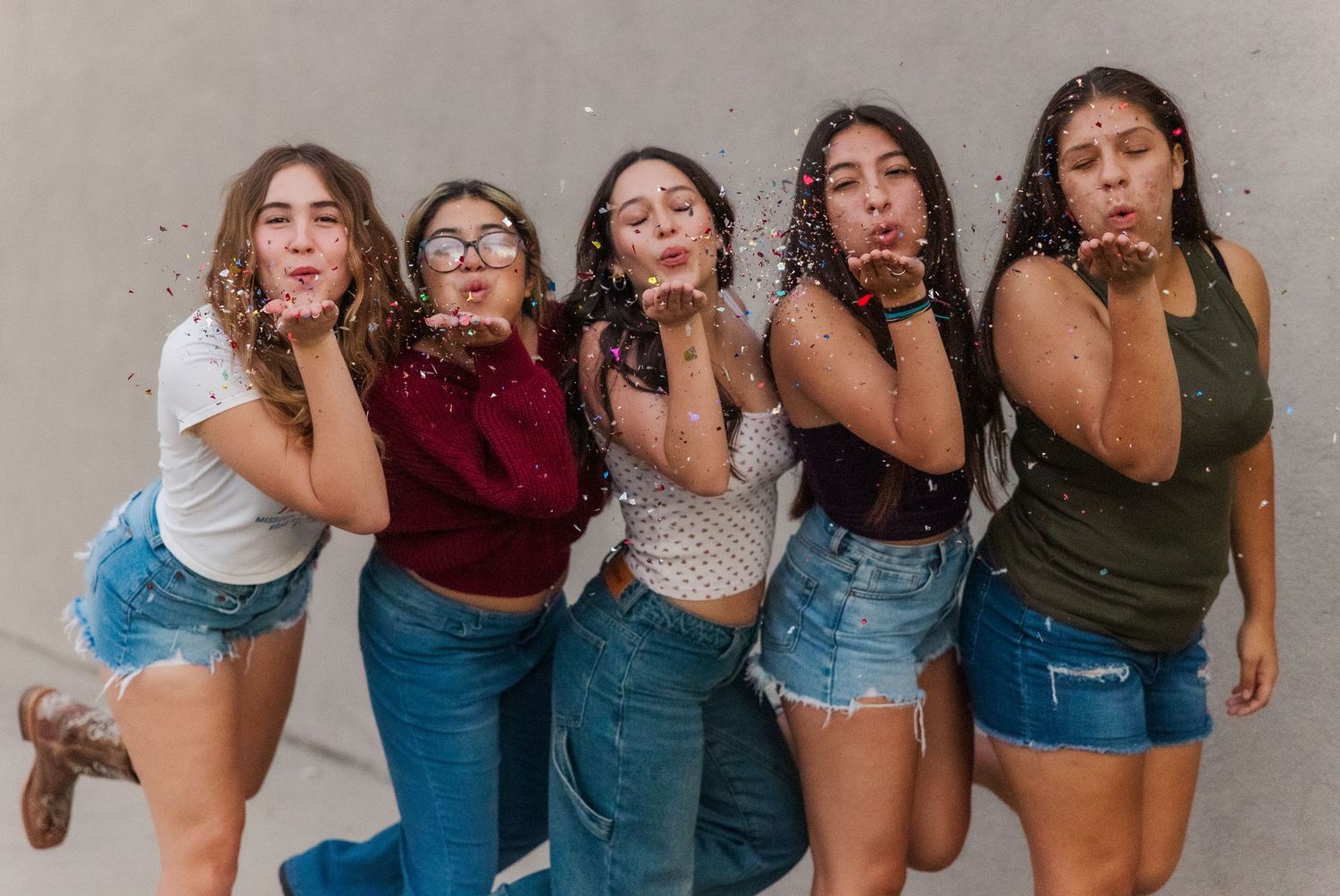 A group of friends in casual denim outfits posing together in a candid summer series of shots.