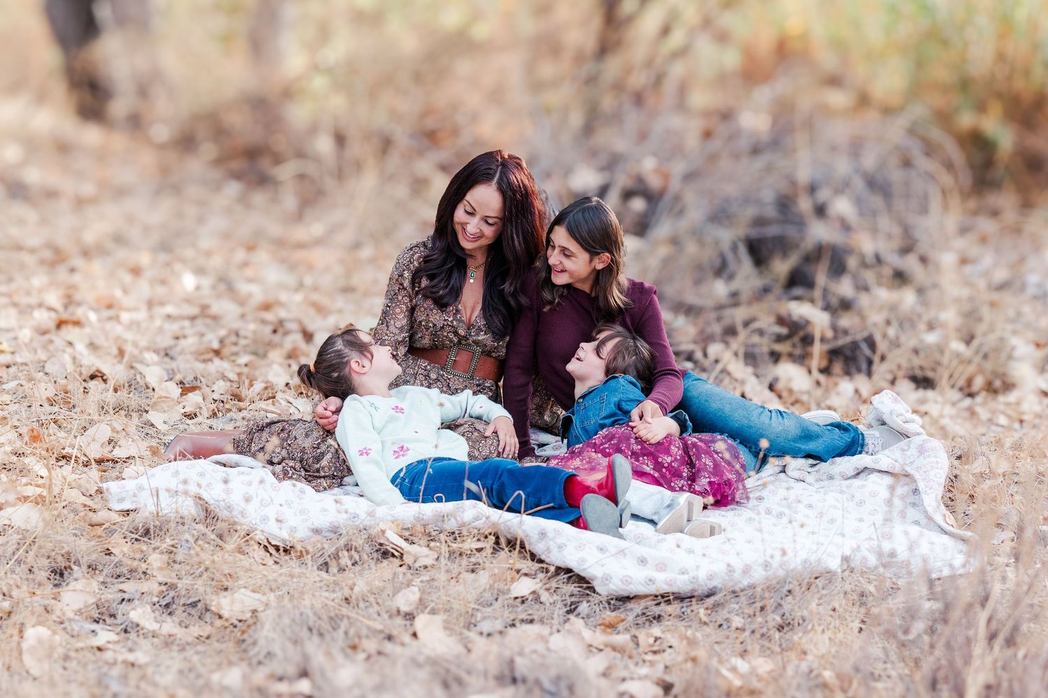 Mother and daughter share sweet moments lying on a blanket outdoors for a casual lifestyle photography session.