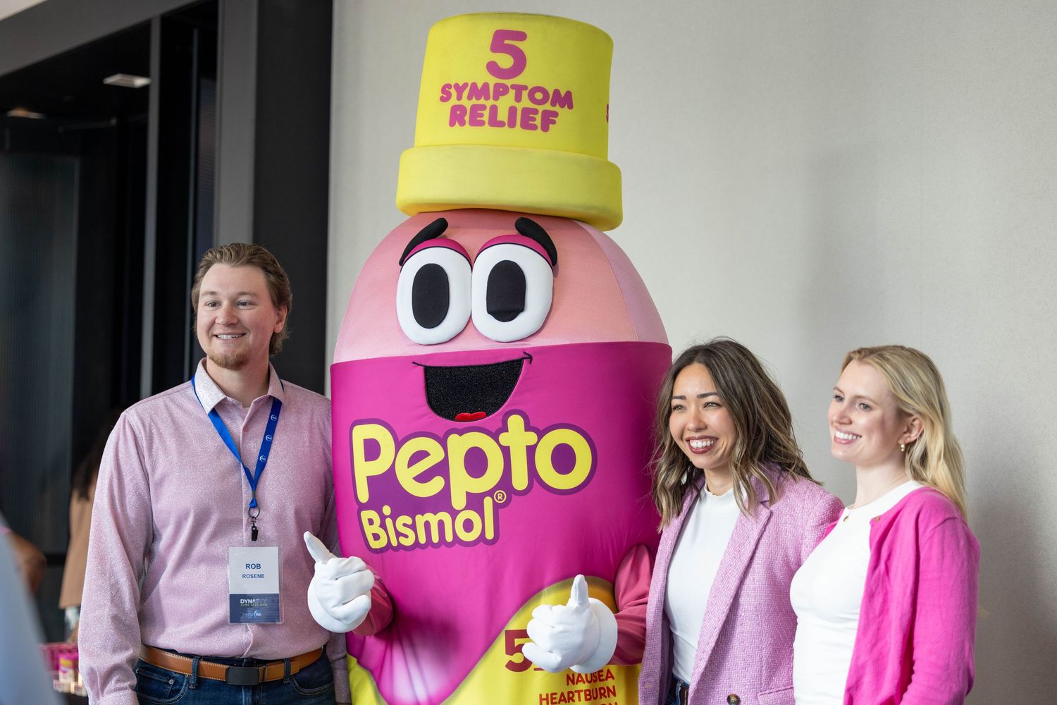 Healthcare professionals pose with the Pepto Bismol mascot character during a promotional event.