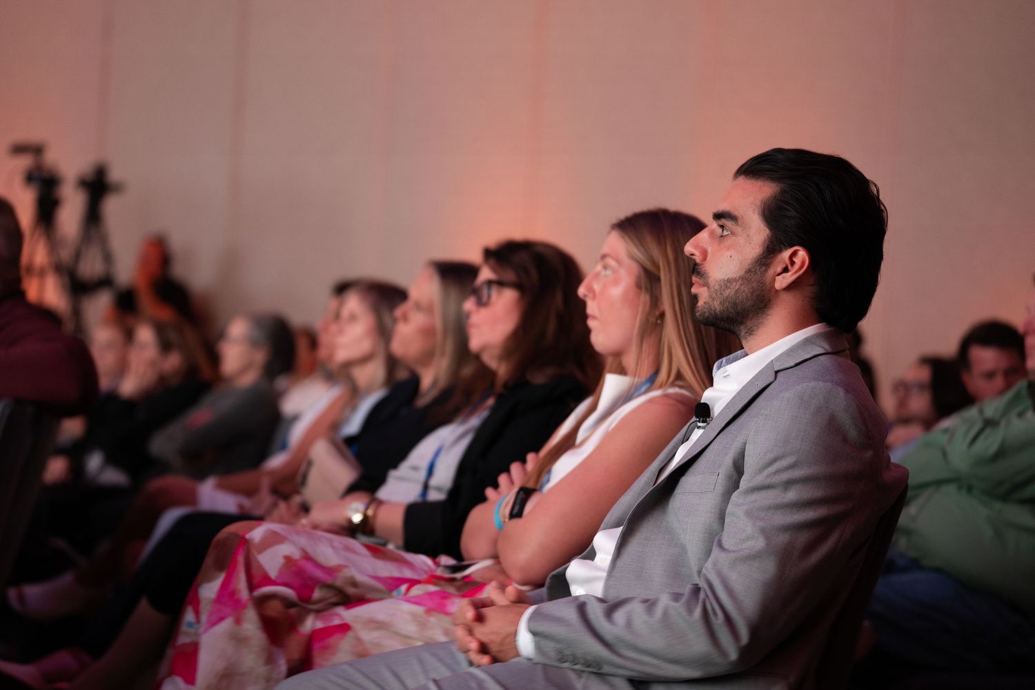 Audience members seated in rows attentively watching a presentation at an indoor event or conference.