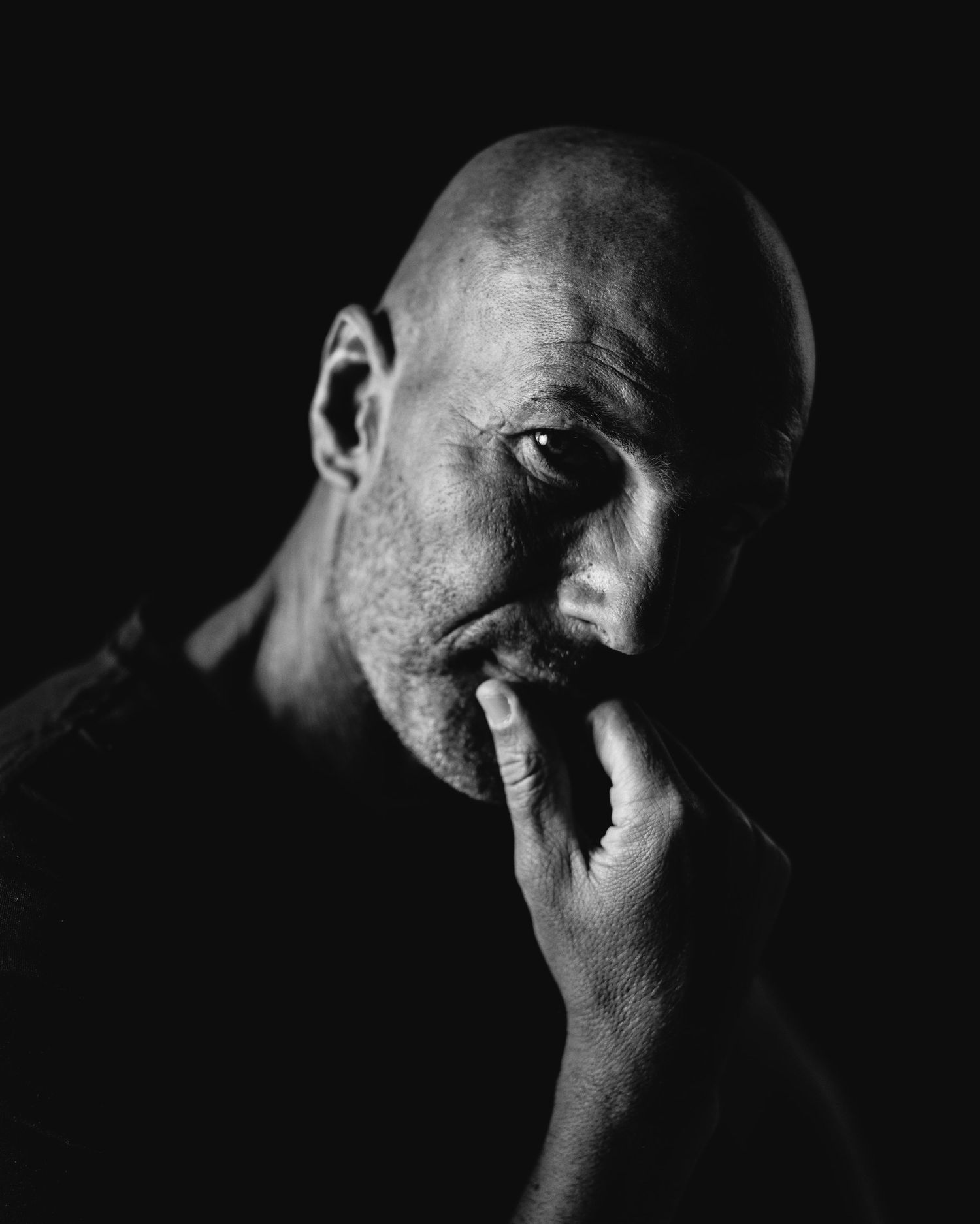 Dramatic black and white portrait series showing emotional expressions in dark lighting.