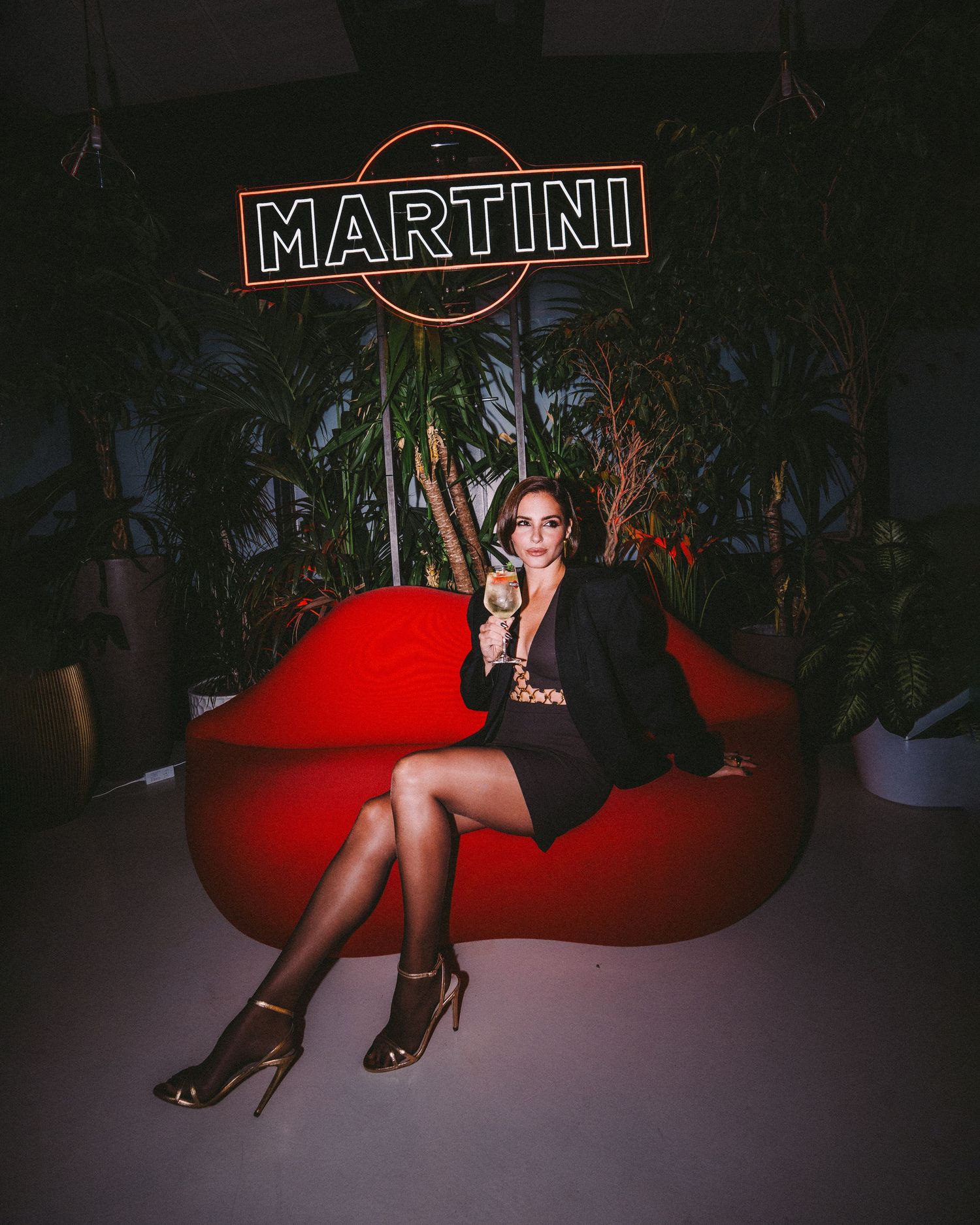 Moody nighttime shots at a bar with red neon Martini sign and lounge seating.