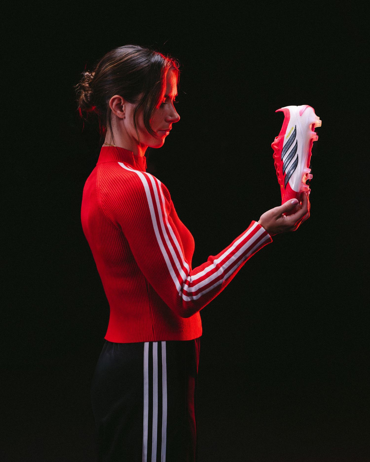 A person in a red shirt and white stripes performs a sequence of movements against a dark background.