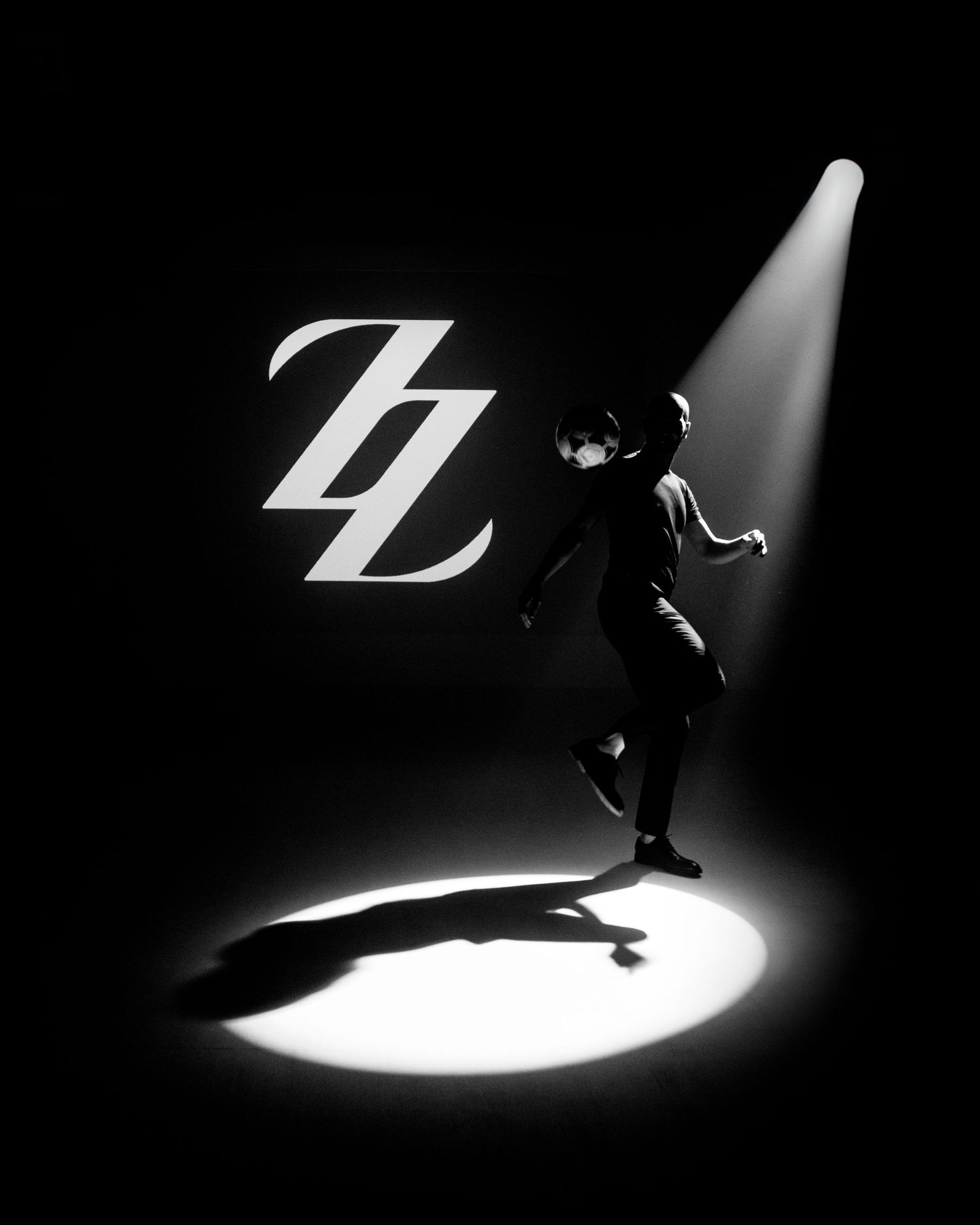 Black and white silhouettes performing dynamic movements against spotlit backgrounds.