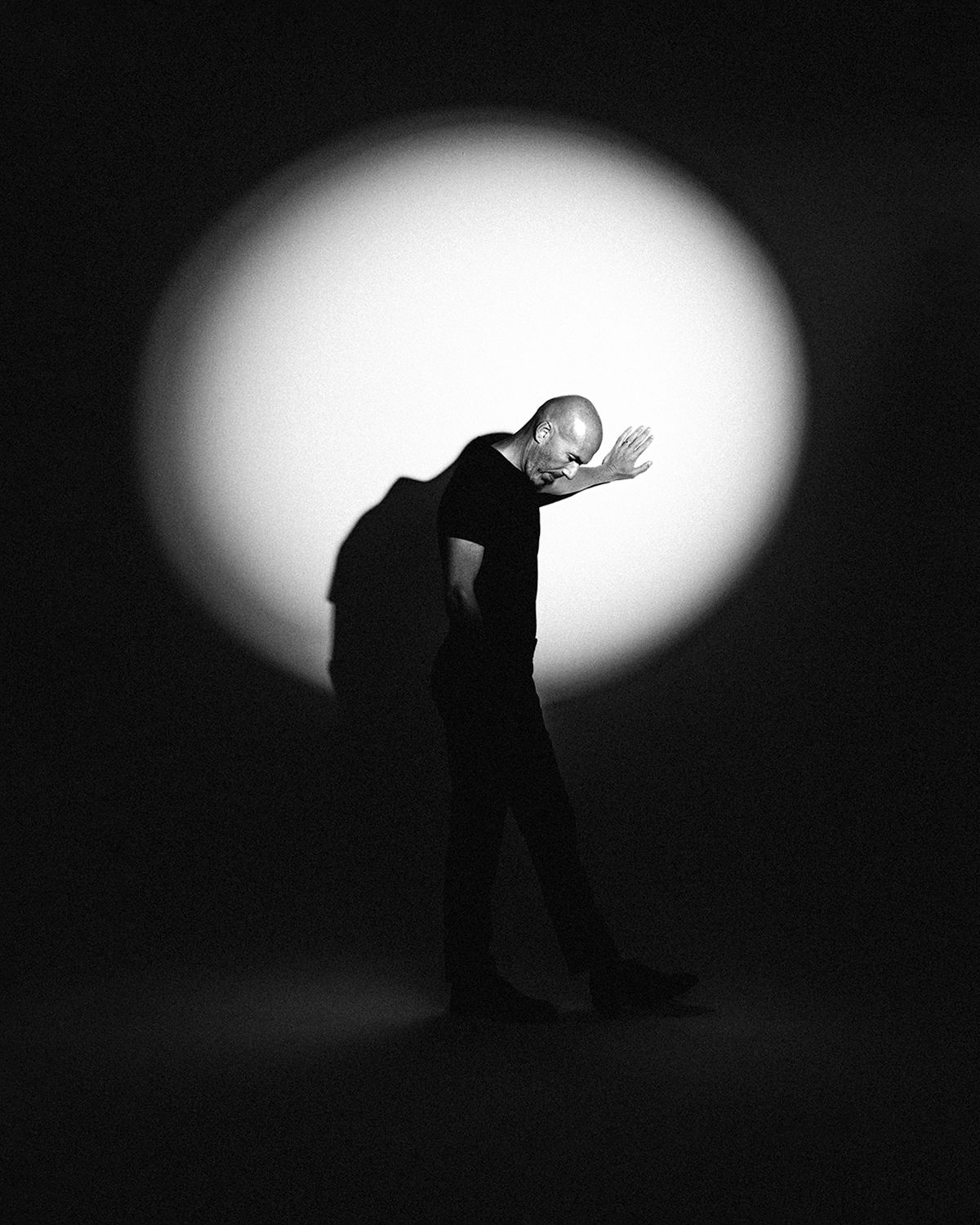 Silhouetted figures in dramatic poses against circular white lighting effects.