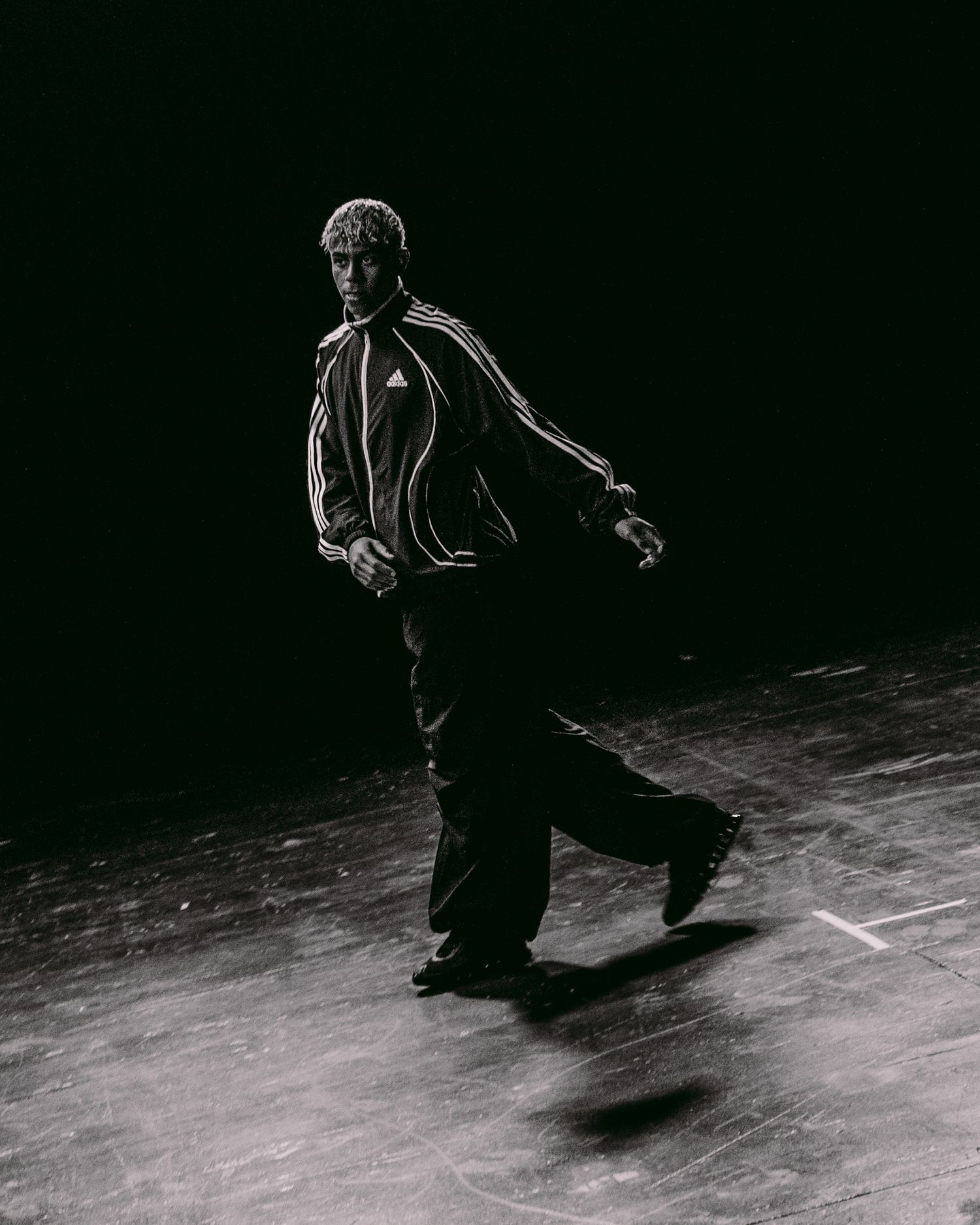 Atmospheric sequence showing silhouetted figure moving across illuminated floor.