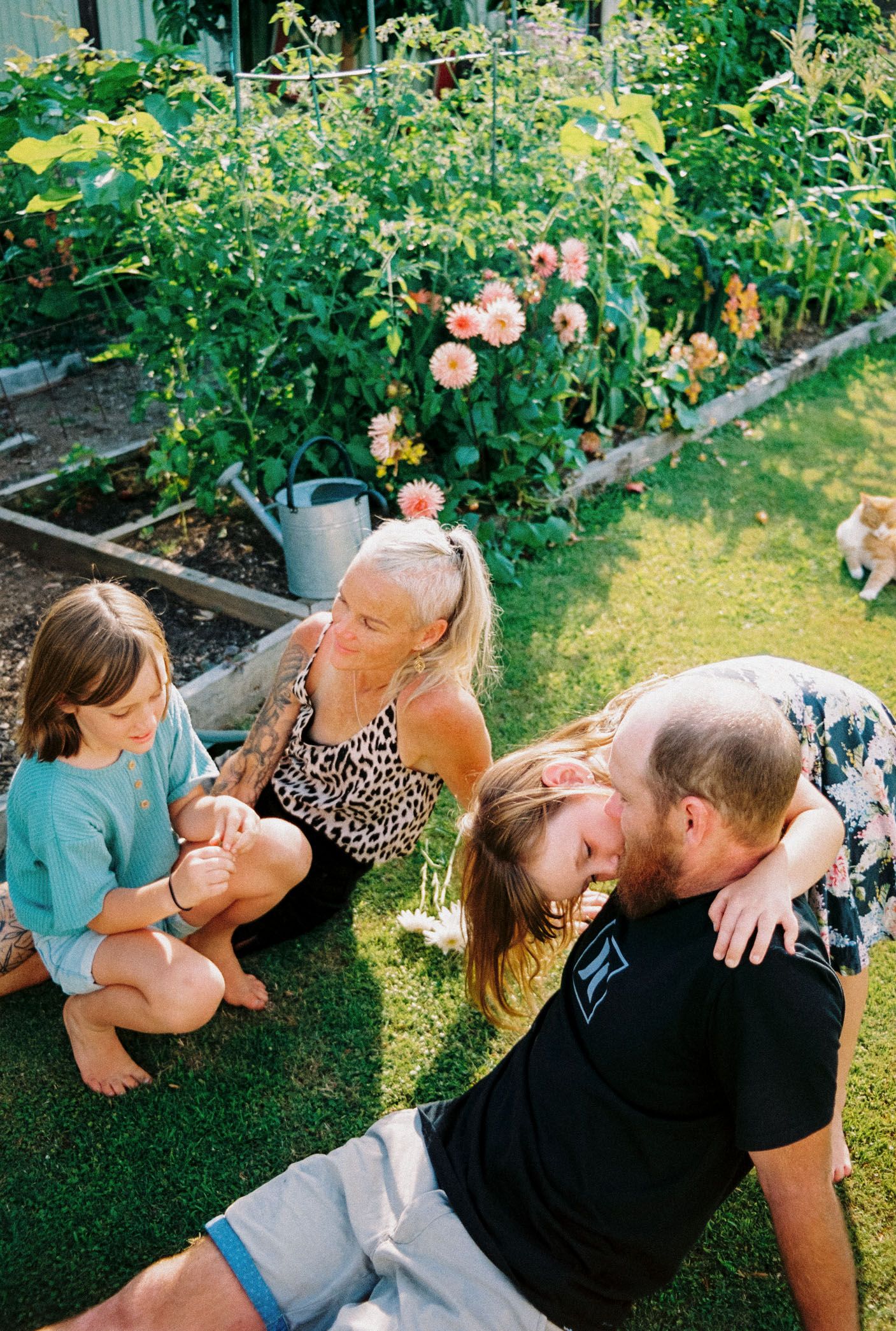 Happy people relaxing and sharing affectionate moments in a summer garden setting with blooming flowers.