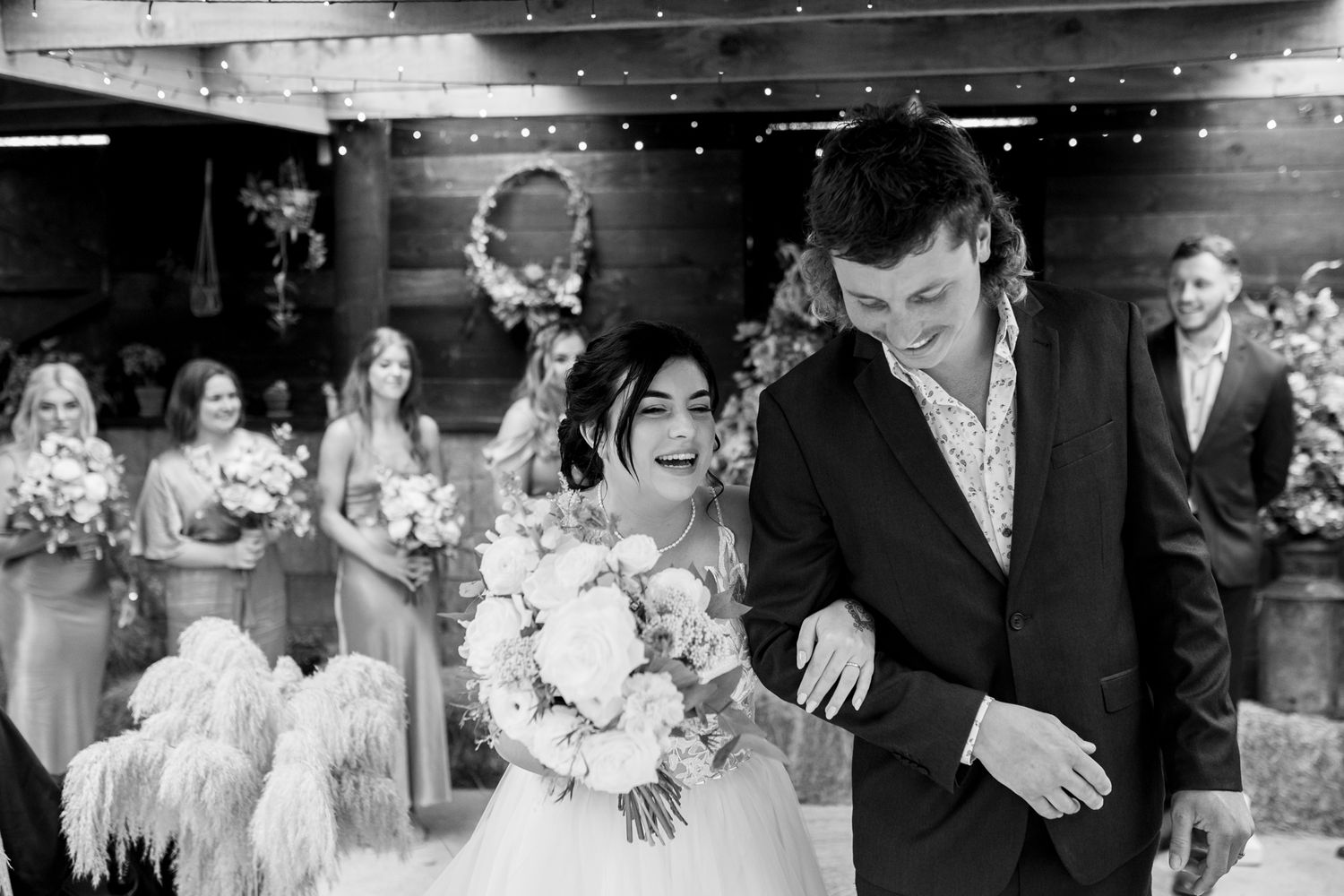 A joyous celebration in a rustic barn venue with string lights and wedding decor.