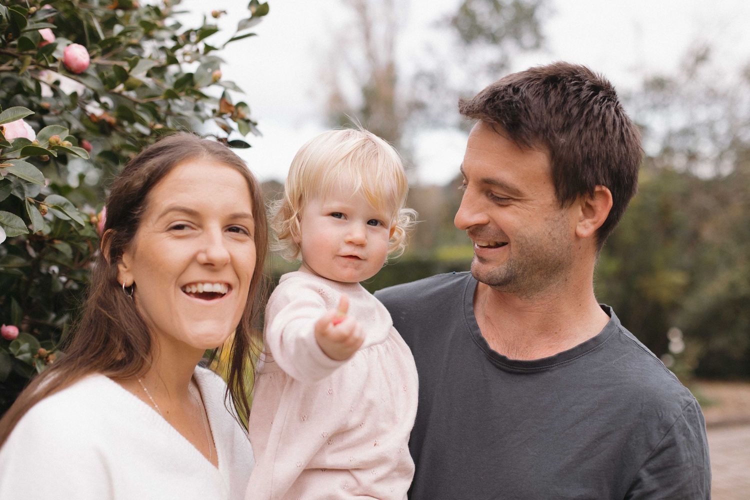 A family shares a candid moment together outdoors in casual attire.