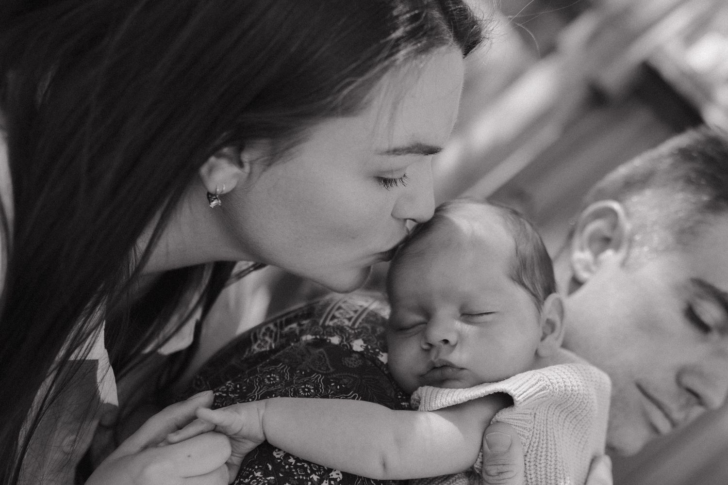 A loving couple shares a romantic moment in black and white as they embrace and kiss.