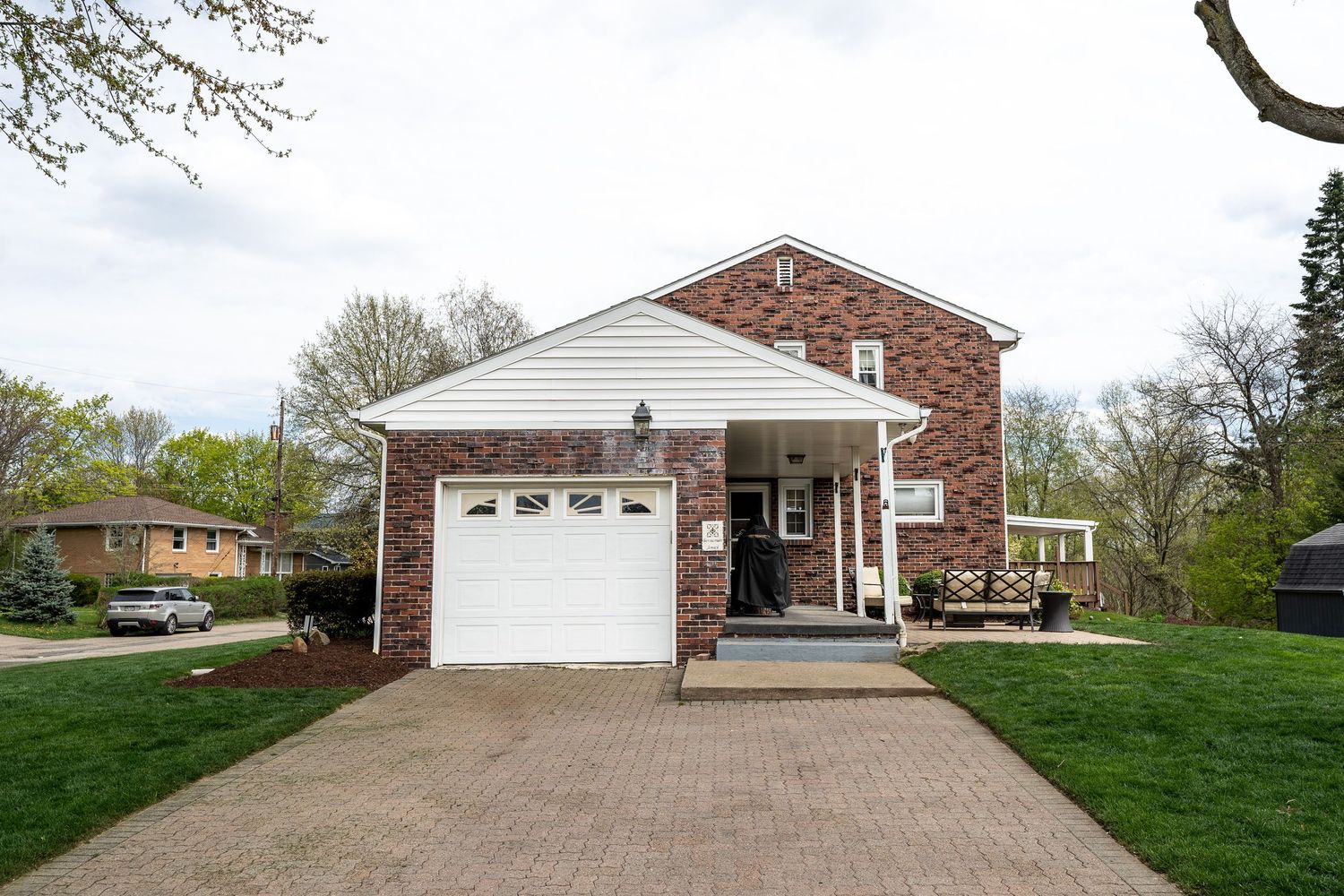 Exterior view of a residential home with white garage door and landscaped front yard in springtime.