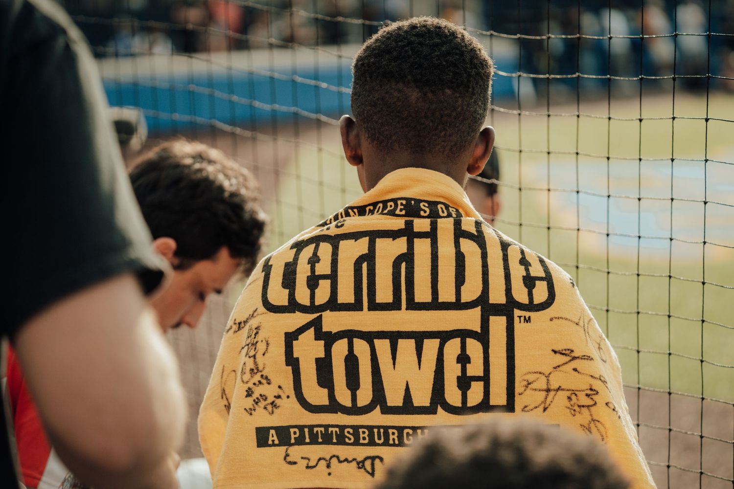 Someone wearing a yellow Terrible Towel t-shirt at a sporting event with a blurred crowd in the background.