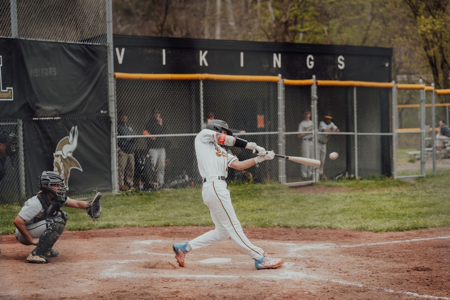 Baseball player swings bat at home plate during Vikings game.