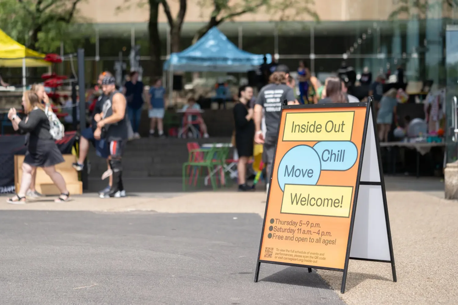 Welcome signs and banners displayed at an outdoor community event venue.