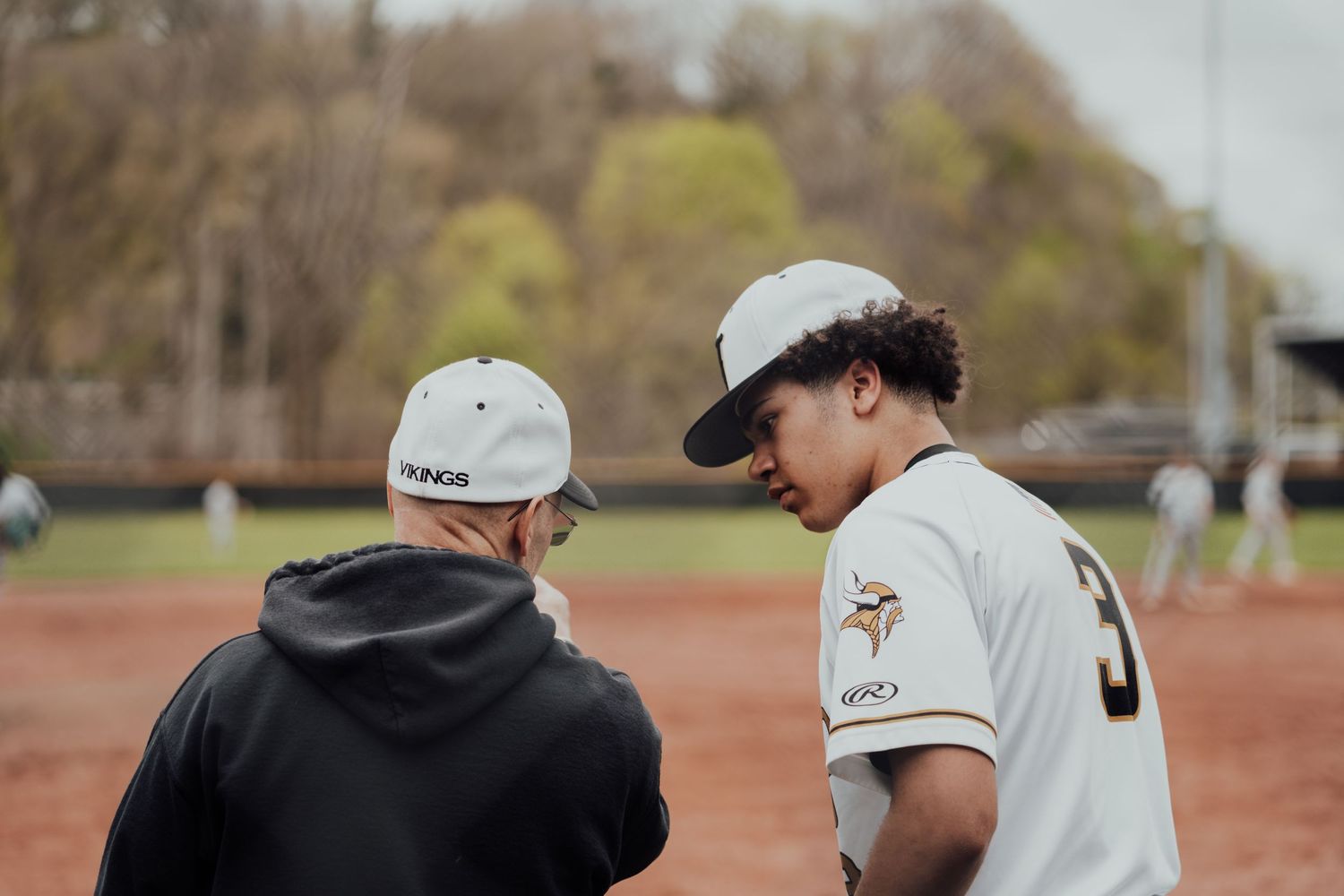 Coach and player have a discussion during baseball practice.