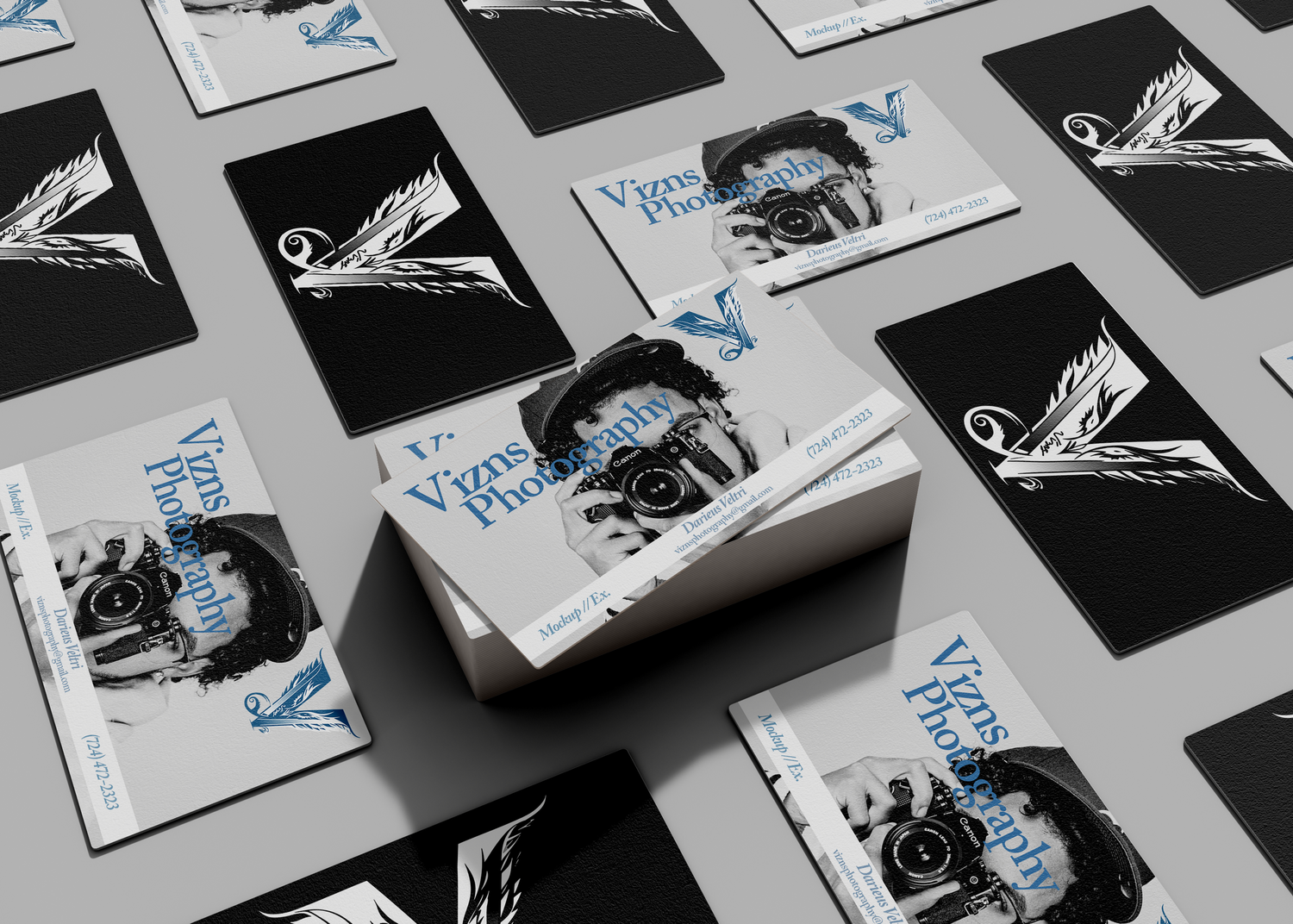 Black and white business cards with blue accents arranged in a repeating pattern on a light surface.