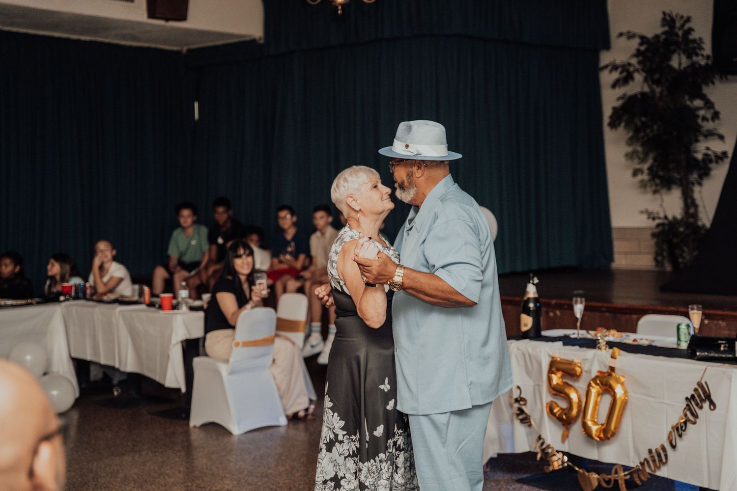 A couple dancing together at what appears to be a 50th anniversary celebration.