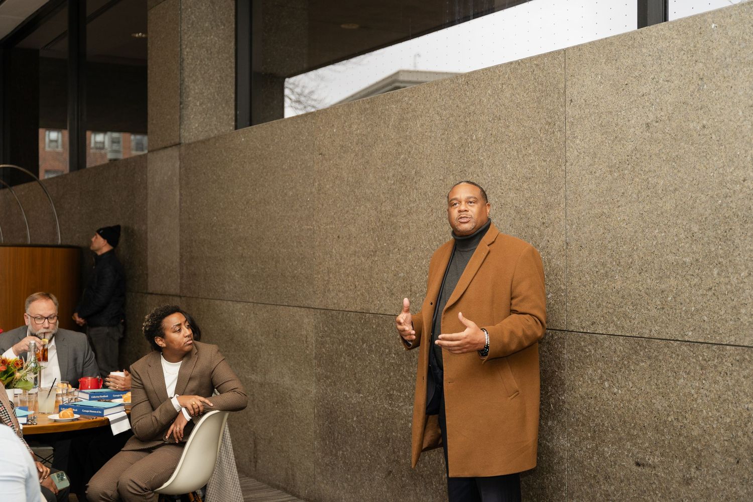 People interacting in a modern concrete hallway with geometric architectural features.