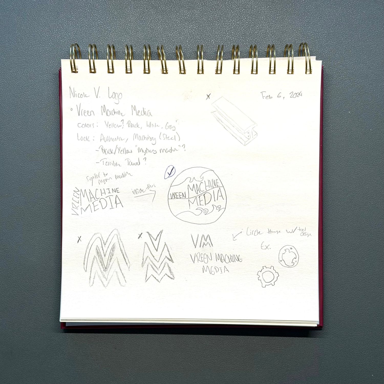 Handwritten sketches and notes on white spiral-bound notepads against a dark background.