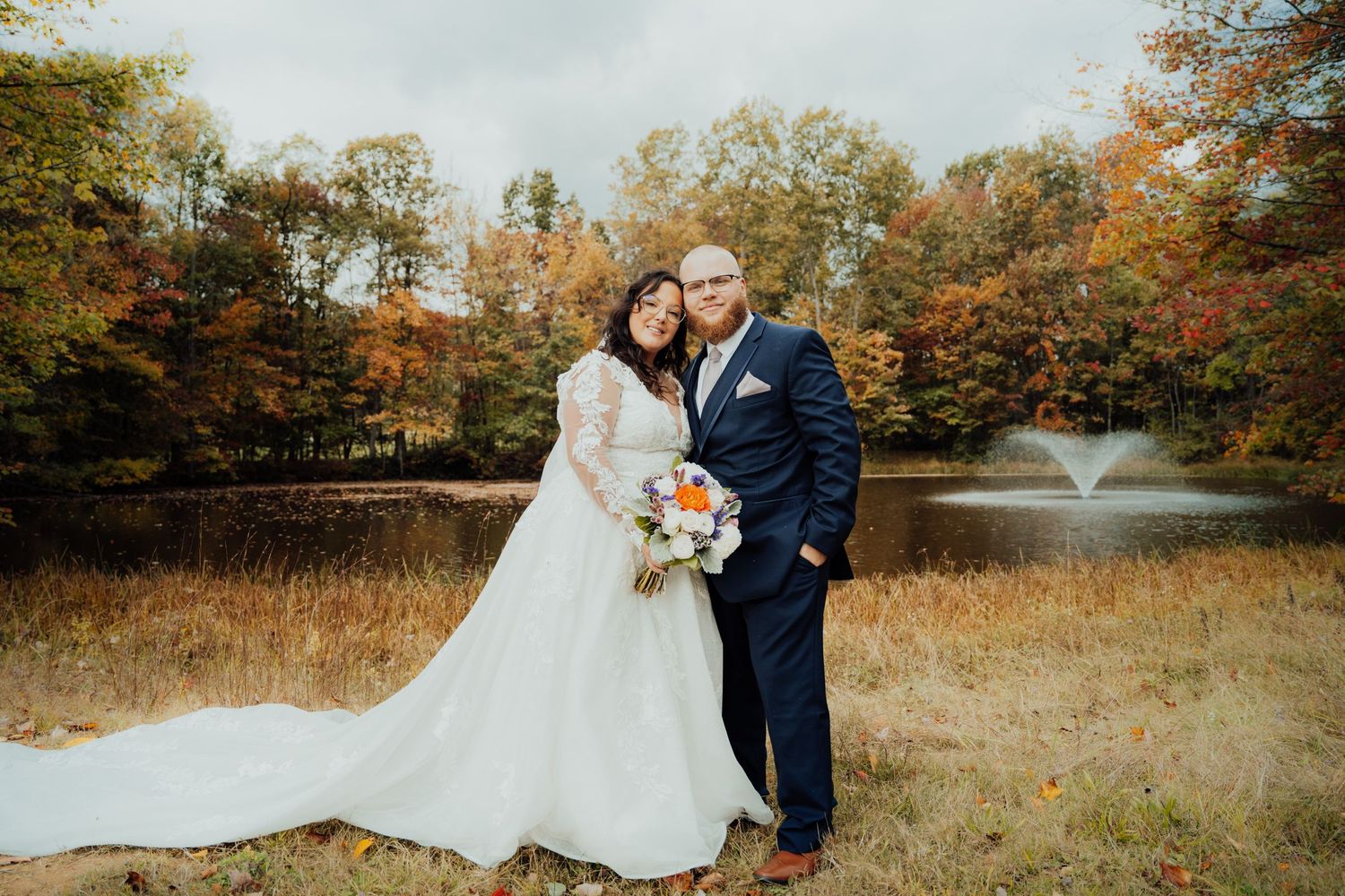 Romantic wedding portraits in a rustic fall landscape with golden grass.