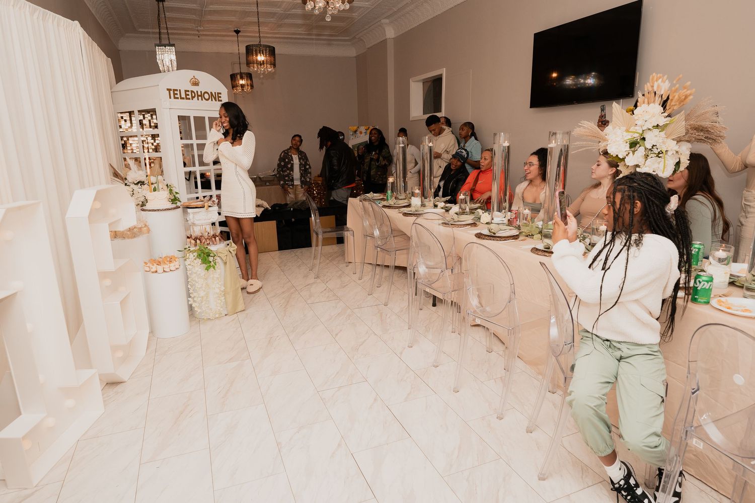 A white-themed party space with elegant table settings and decorative elements.
