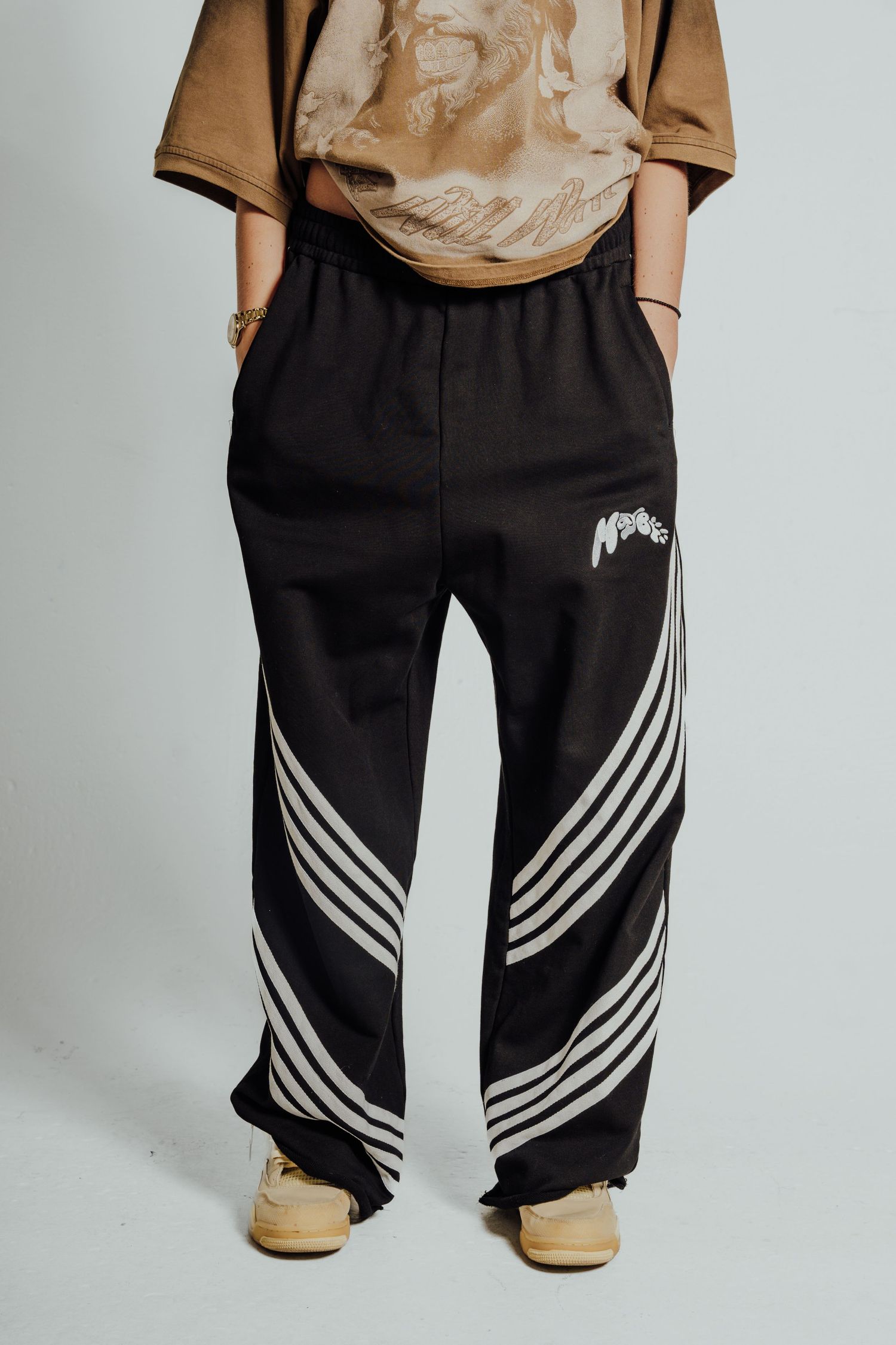 Black athletic pants with white striped design detail shown from waist down.