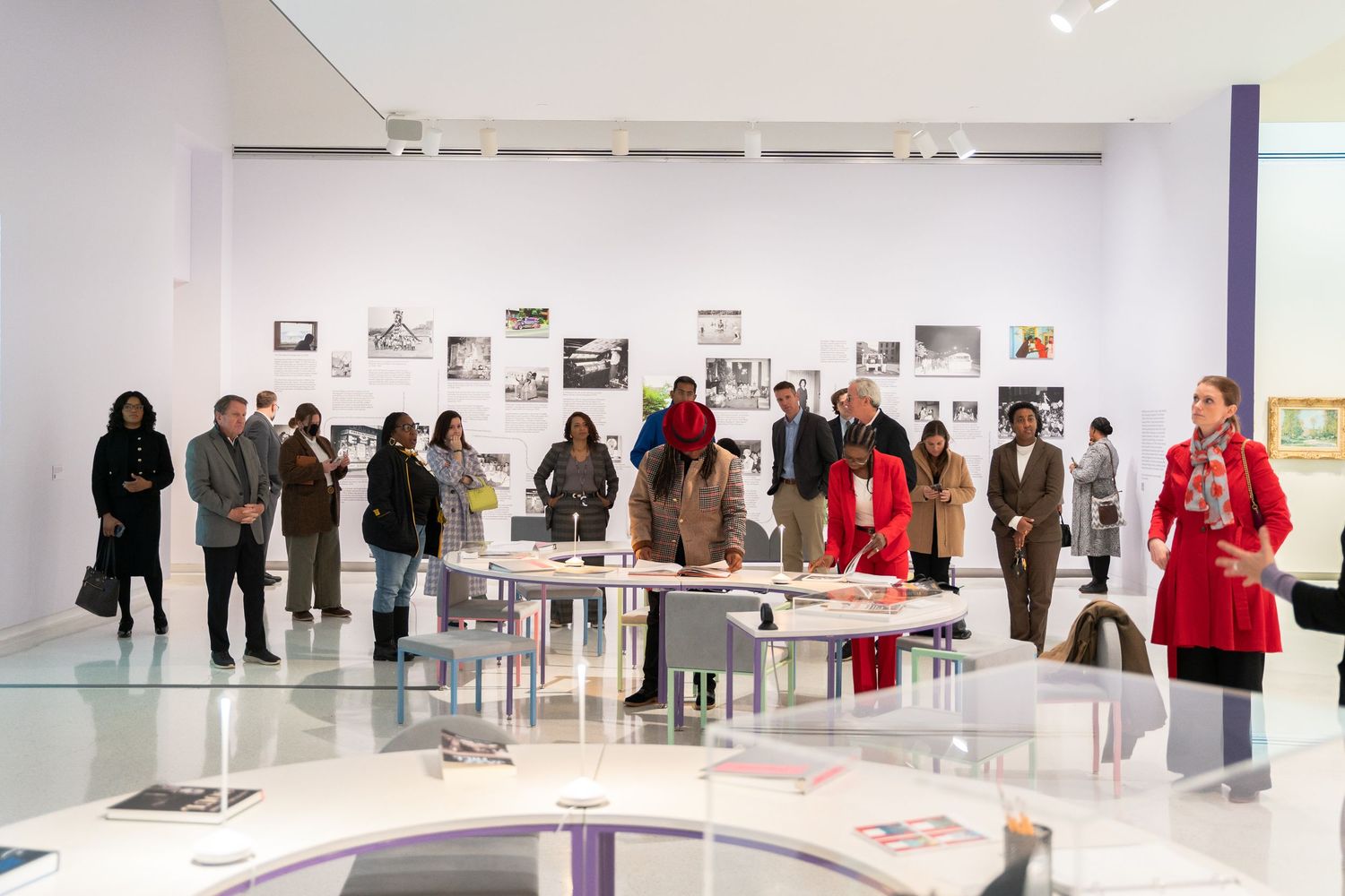 Gallery visitors explore a modern exhibition space with photographs displayed on white walls.