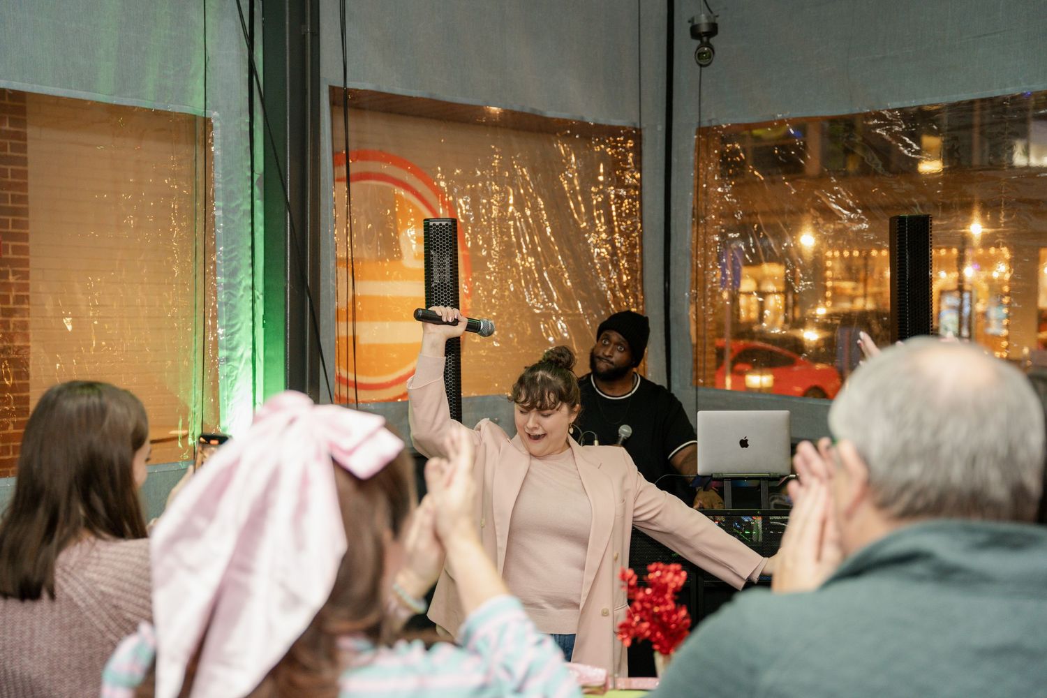 Event guests interacting in a brick-walled venue with ambient lighting and decorative elements.