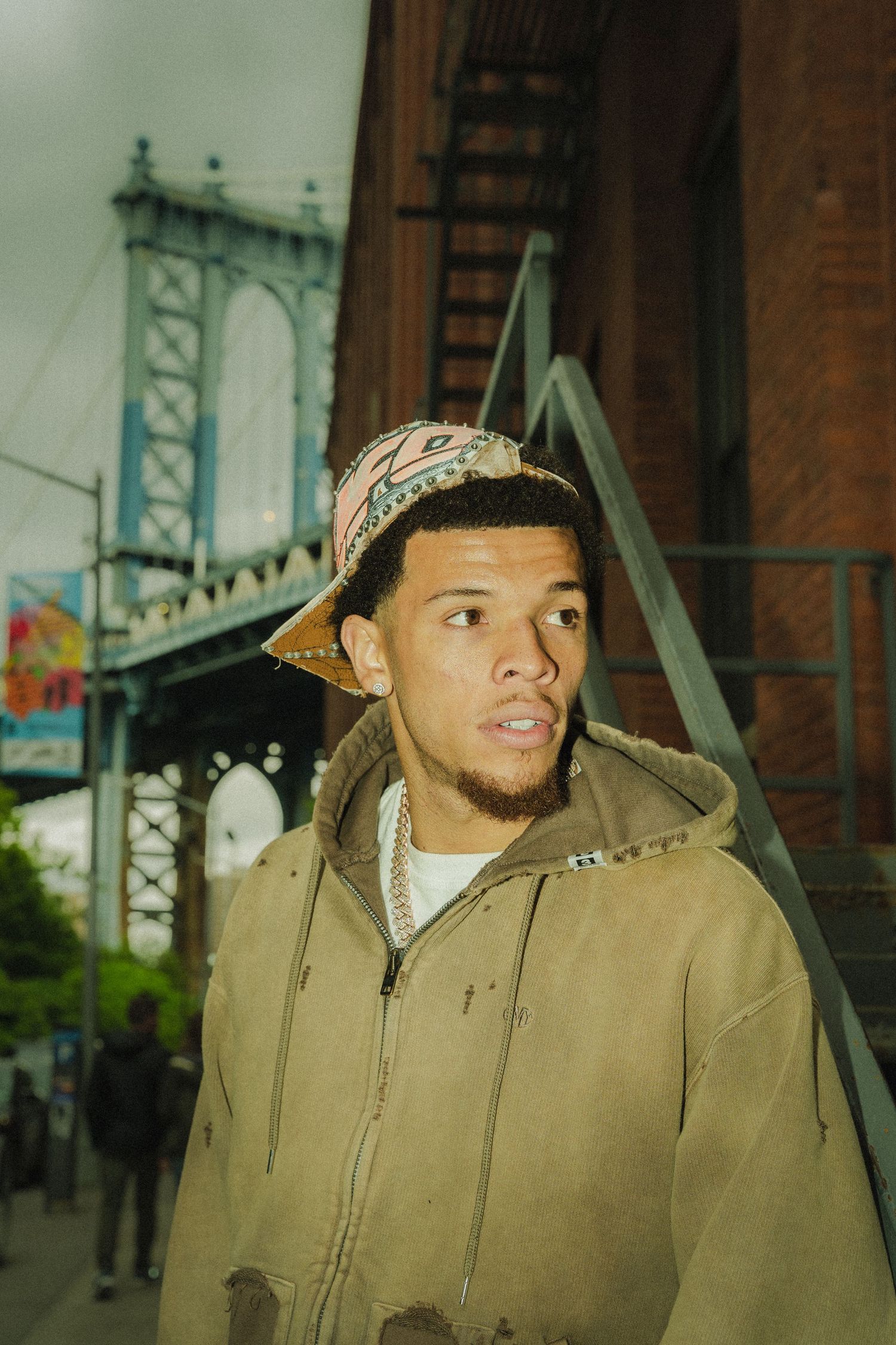 Urban street photography with Manhattan Bridge backdrop in vintage film style.