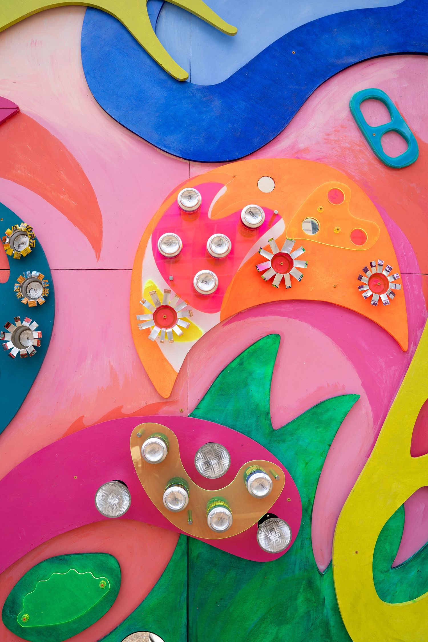 Colorful abstract wall art with vibrant pink, blue, and green shapes decorated with metallic button accents.