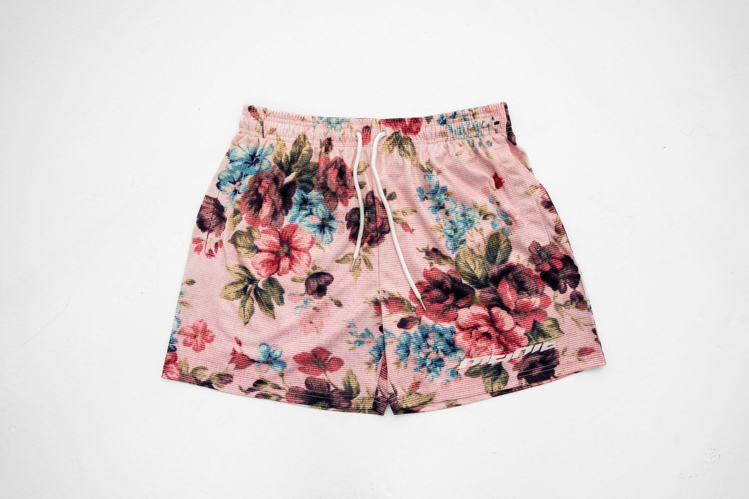 Pink floral pattern shorts with vintage-style design on white background.