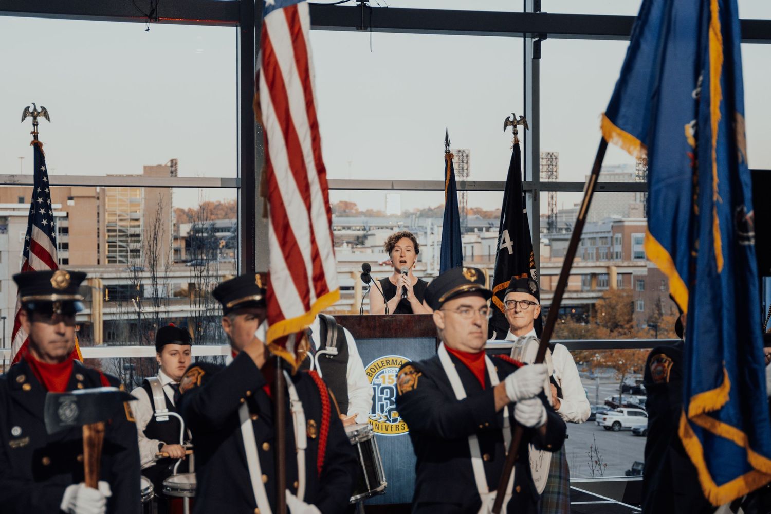 Color guard members holding American flags and rifles during a ceremonial presentation.