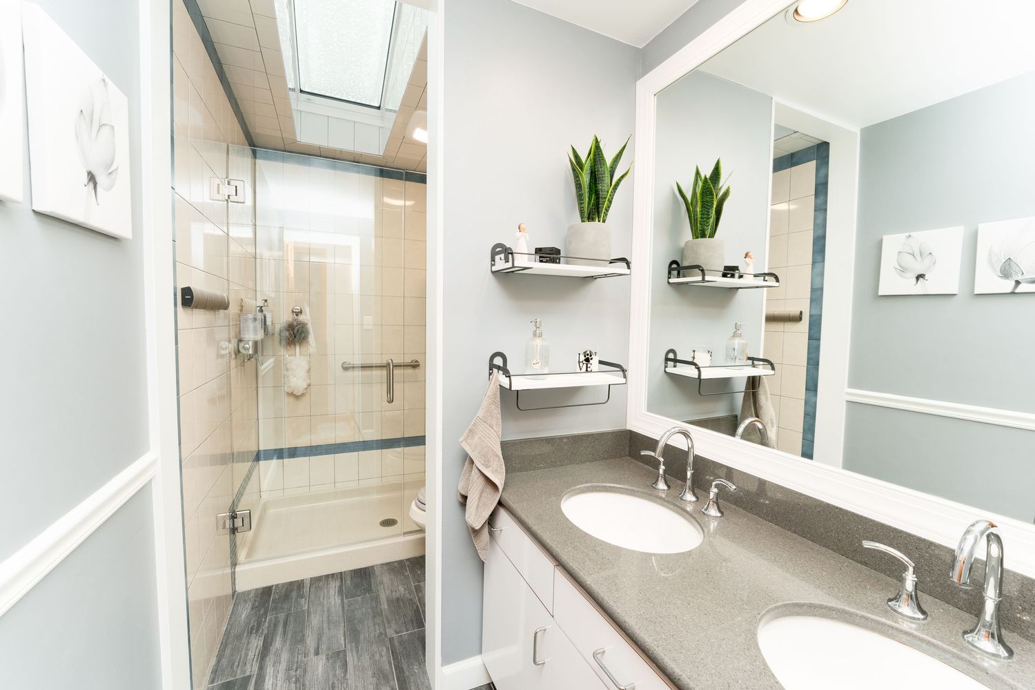 Modern bathroom interior with light blue walls, marble-look tile, and chrome fixtures showcases a clean minimalist design.