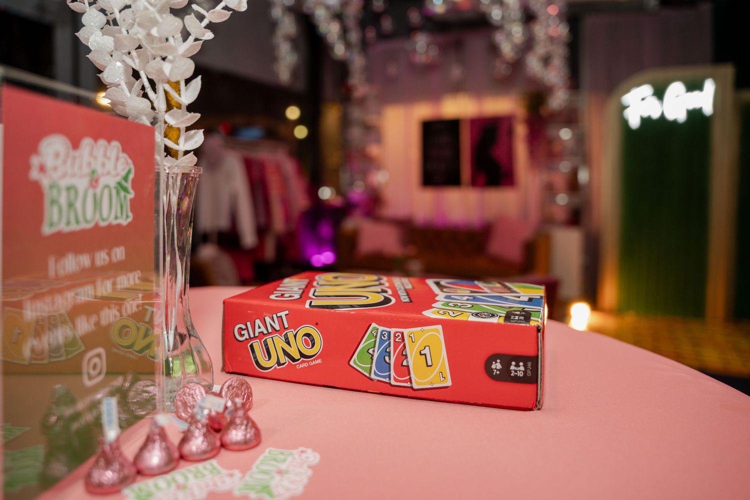 Close-up of decorative white floral arrangements against pink and neon lighting.