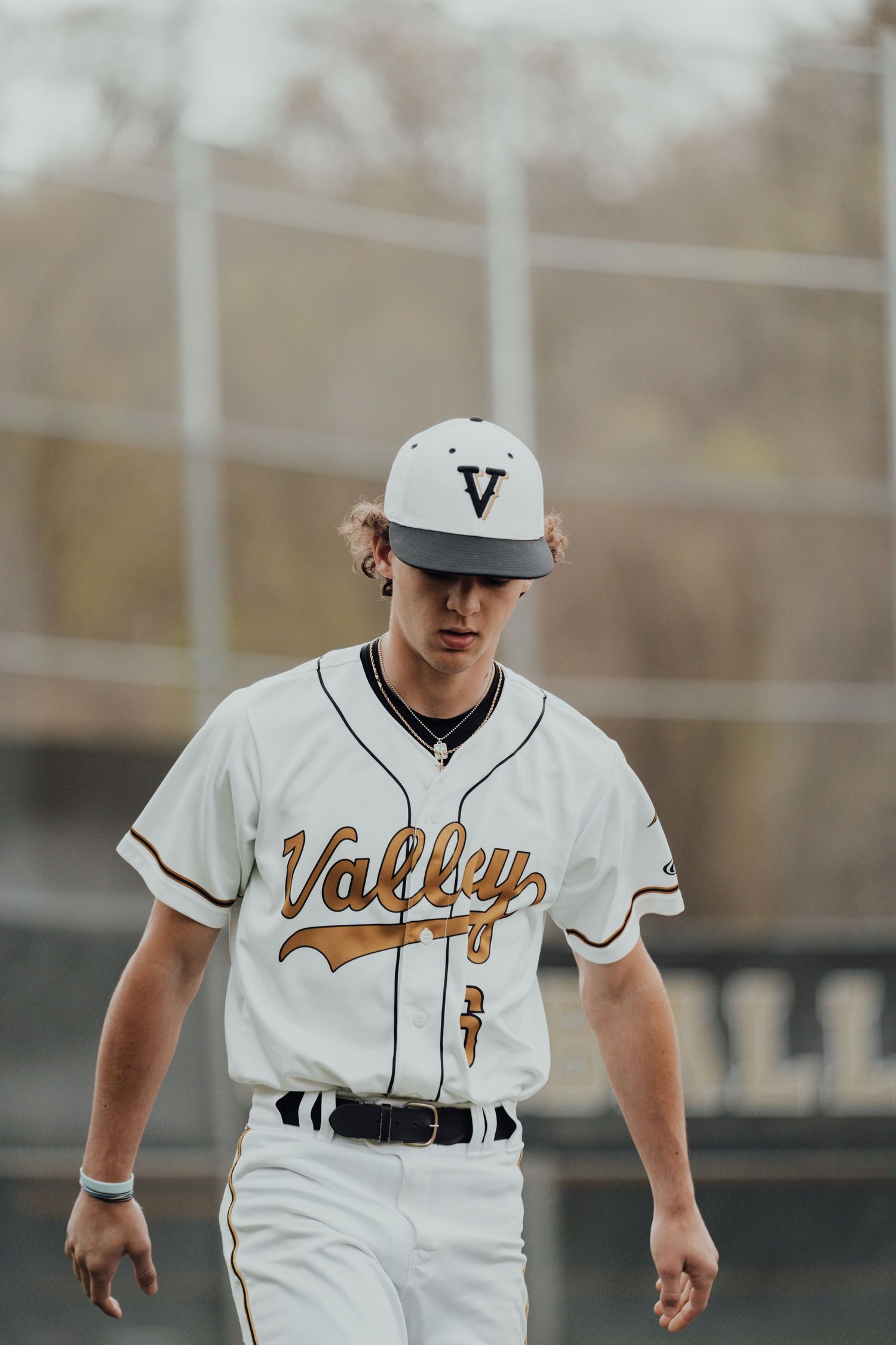Baseball player wearing a white Valley uniform stands in professional batting stance on field.