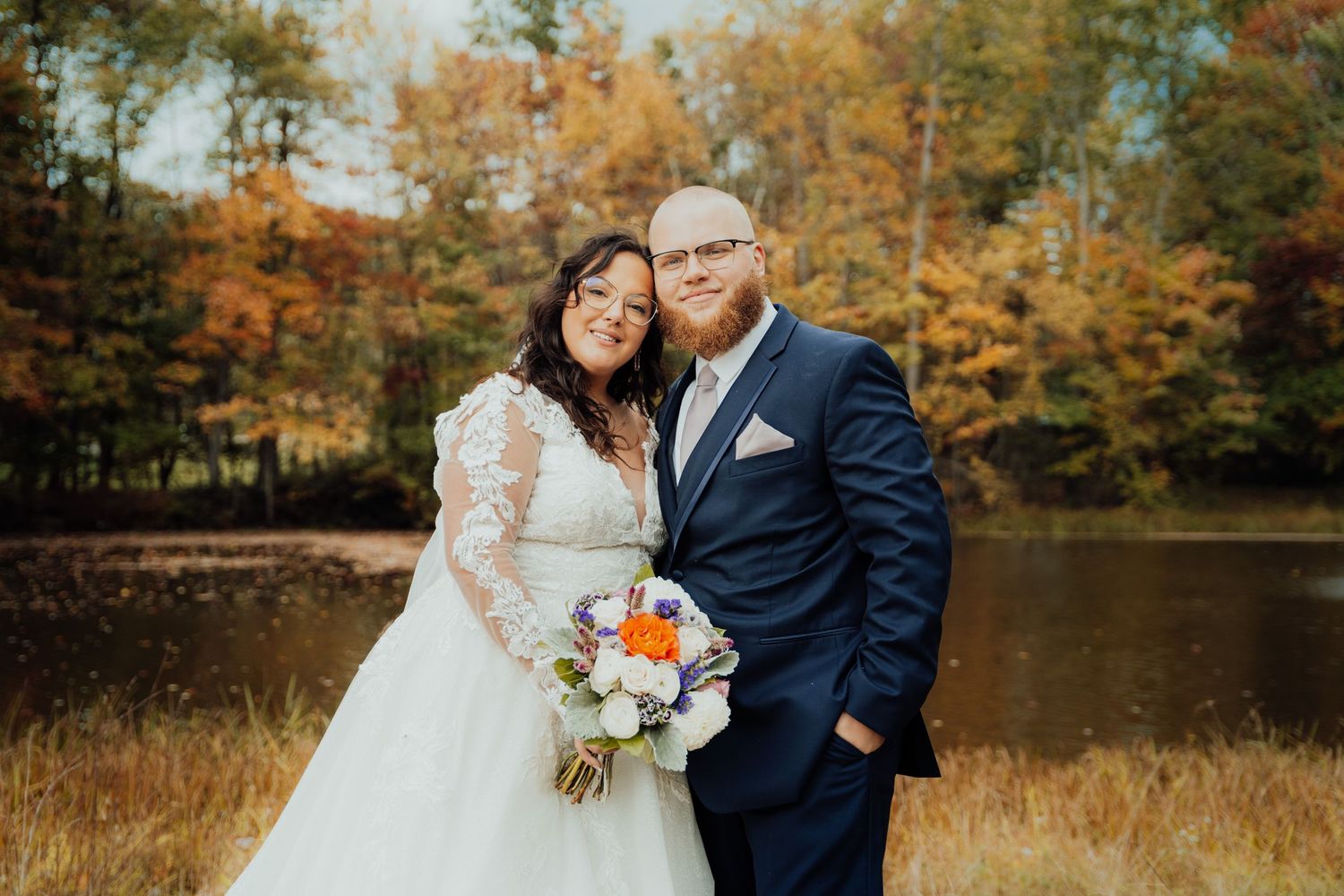 Autumn wedding photography with natural fall foliage and lake backdrop.