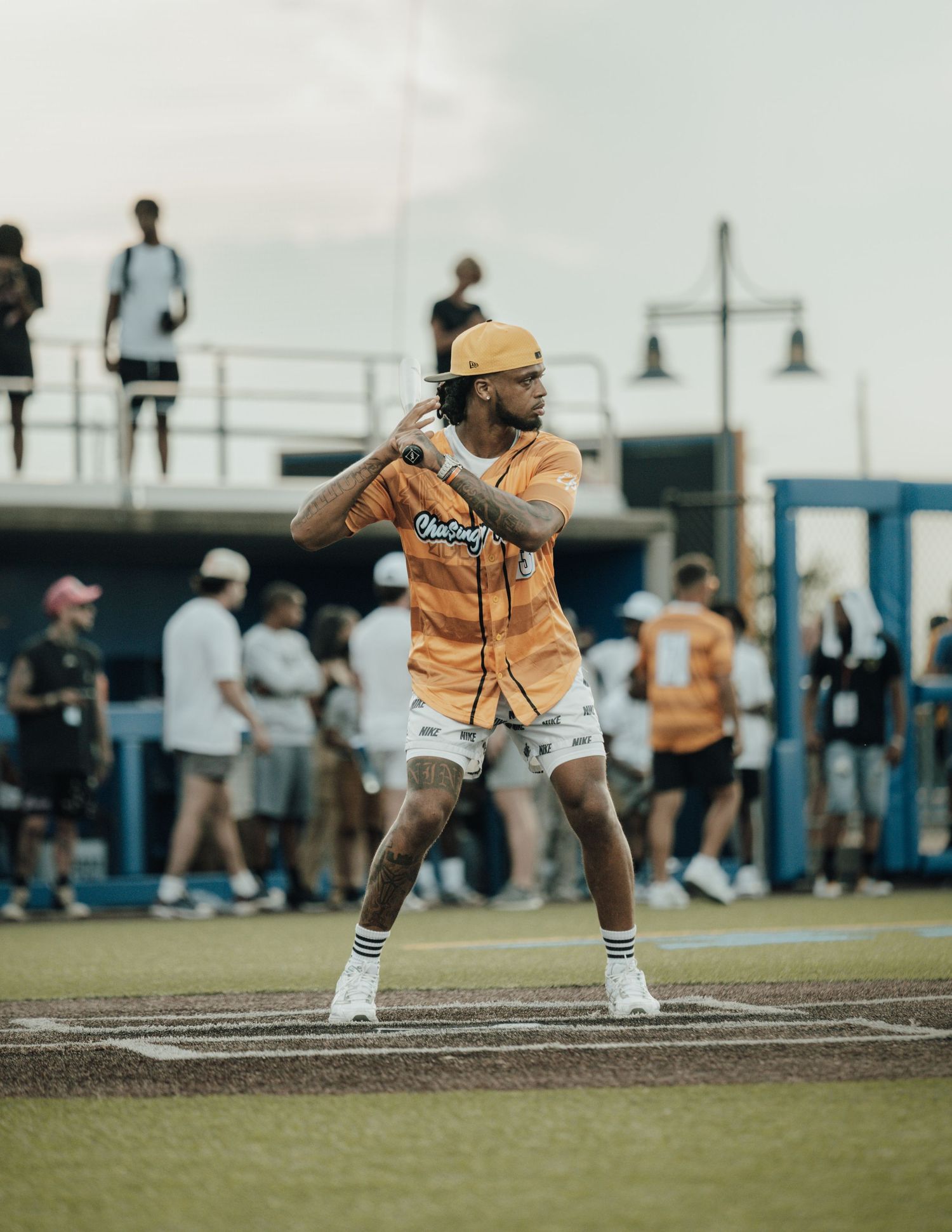 Professional athlete demonstrates split leg stance during baseball game training on outdoor field in summer.