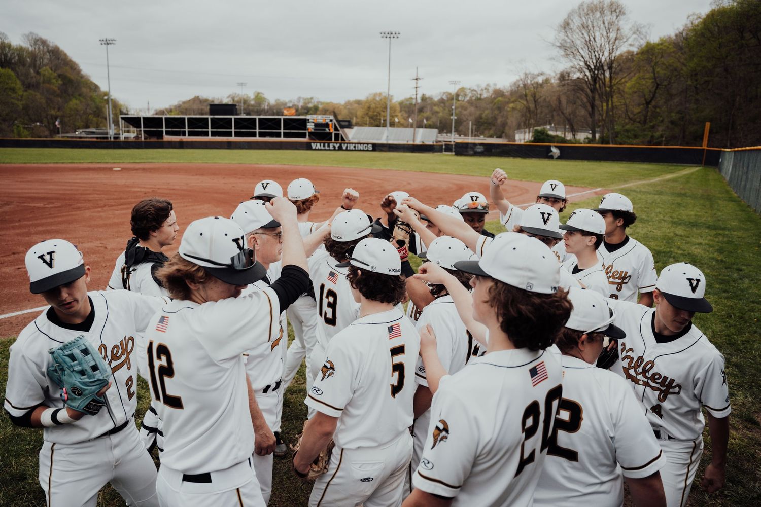 Baseball team huddles together on the field during a game or practice session.