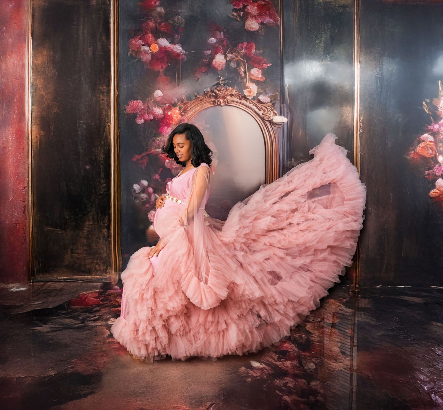 A figure in a flowing pink tulle gown poses gracefully against a dark backdrop with cherry blossoms.