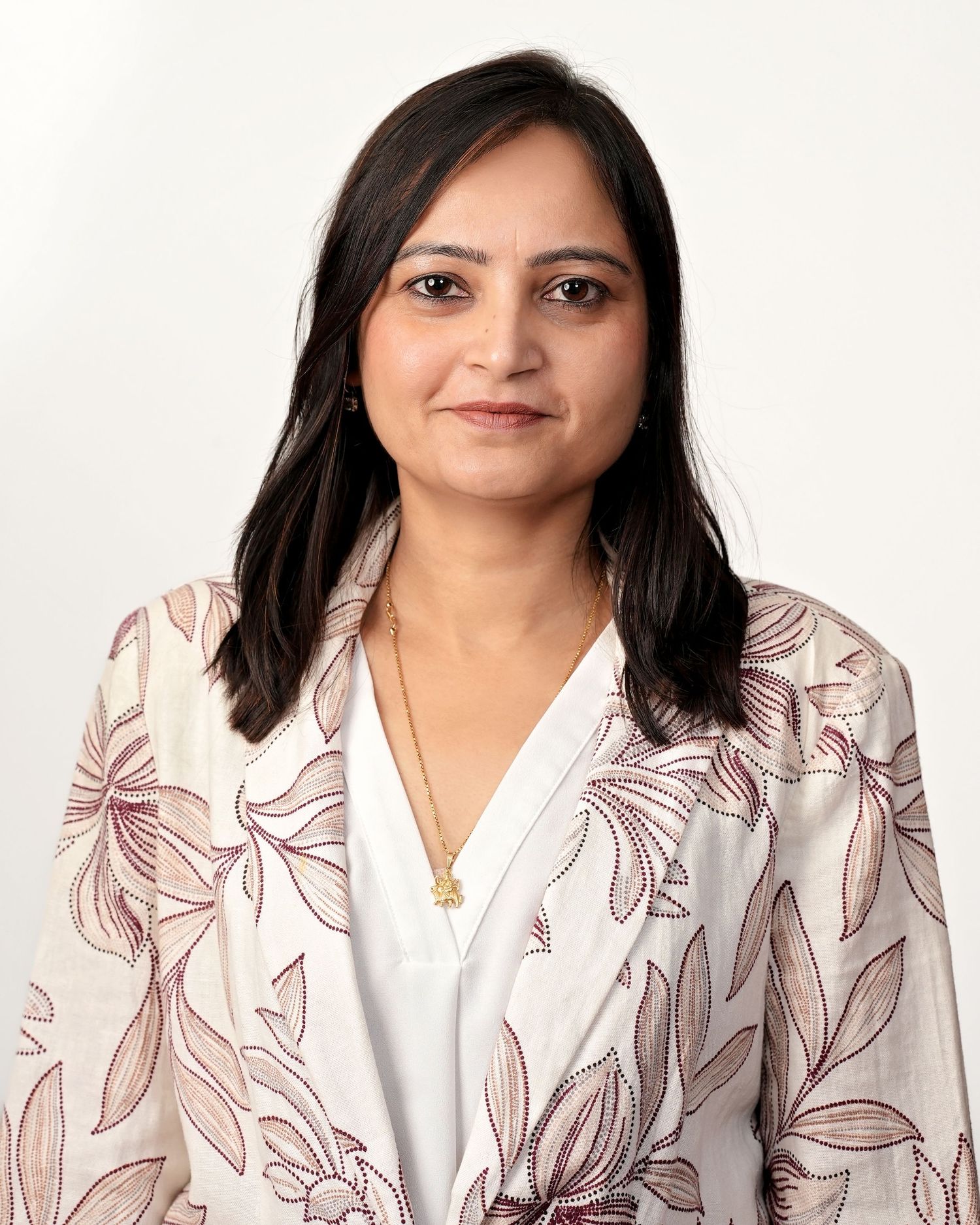 Professional portrait series showing person in white blouse and floral patterned blazer against light background.