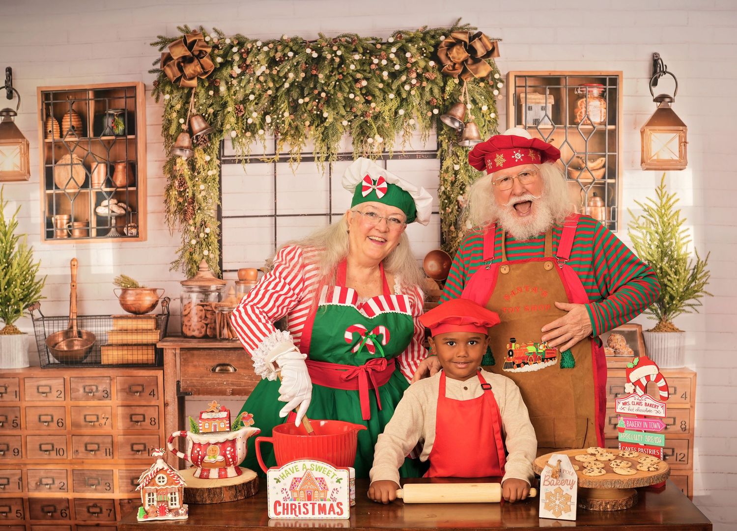 Holiday scene in old-fashioned kitchen with decorative garland, baking tools, and festive red and green outfits.