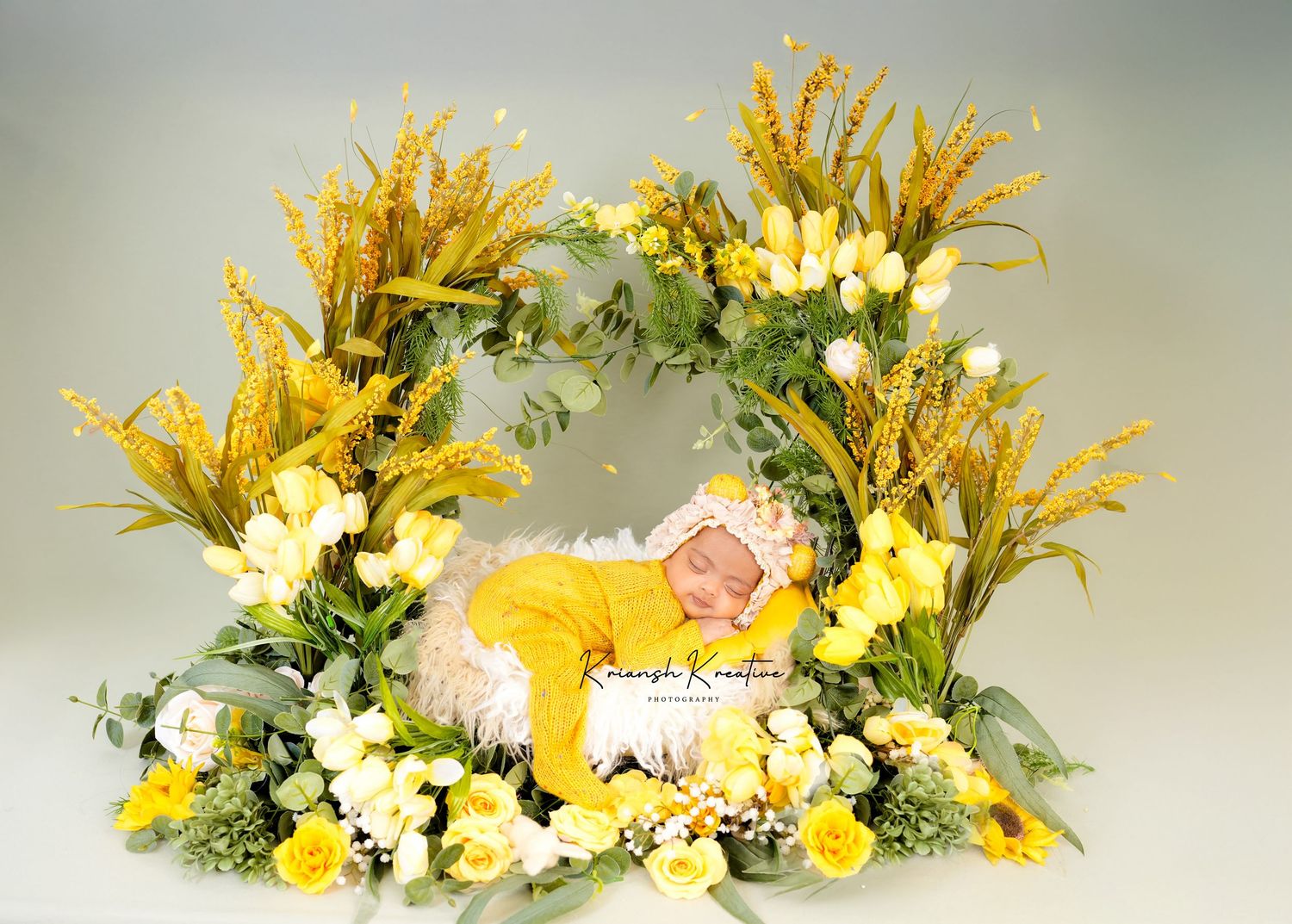 A yellow and white floral crown decorated with bright daisies and delicate greenery sits against a soft gray background.