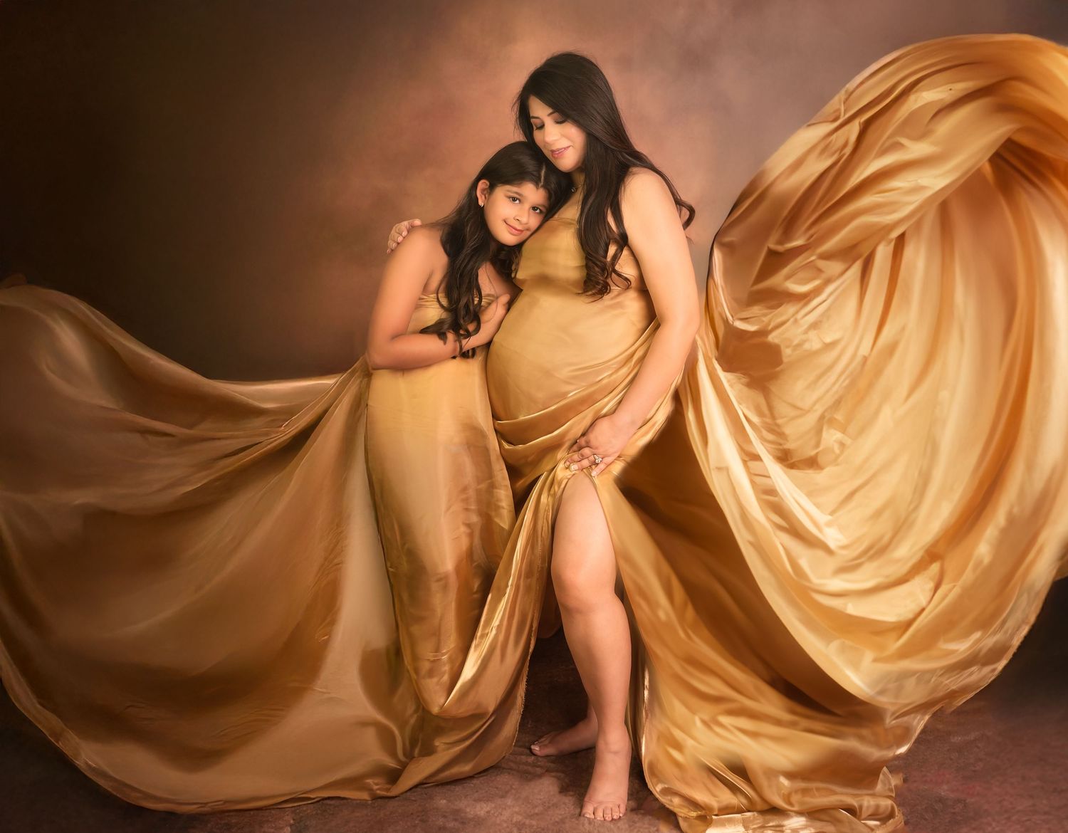 Flowing gold silk fabric creates elegant movement and dramatic curves against a dark background in a fashion photograph.